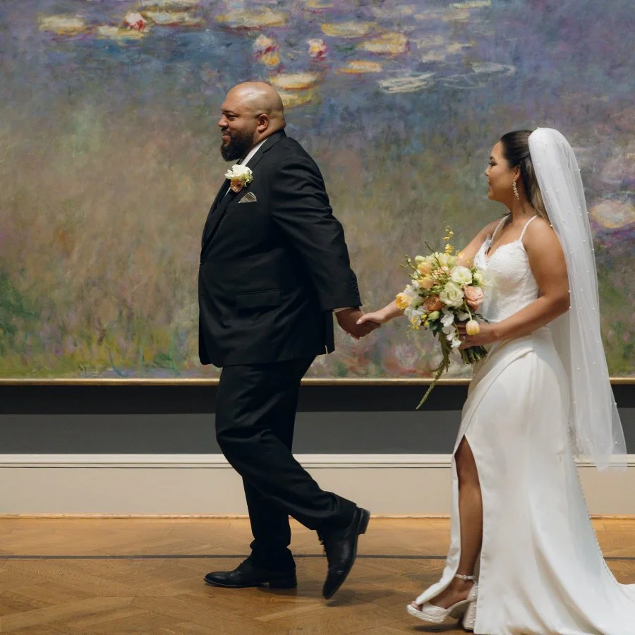 Bride and groom walking in the St. Louis Art Museum in front of the Monet painting with a bridal bouquet by Belli Fiori.