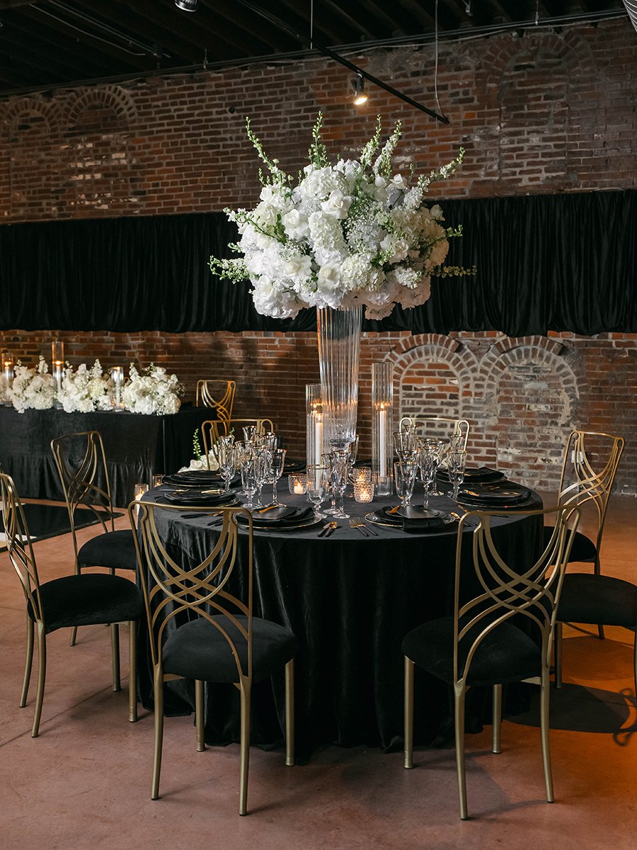 Art Deco inspired wedding table design with tall white floral centerpiece by Belli Fiori at the Gatsby Events Venue in St. Louis.