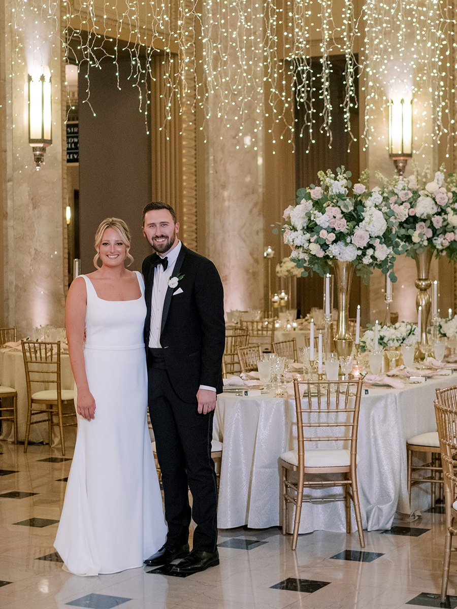 Bride and groom standing by their head table at the Stifel Theater in St. Louis.