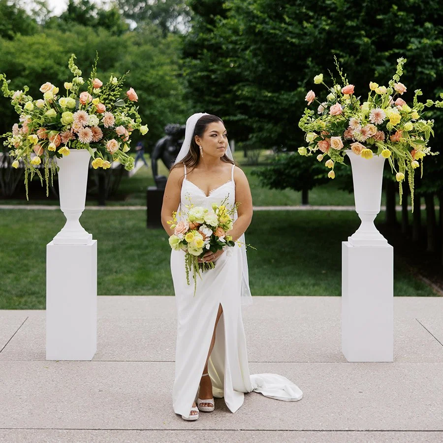 Bride with her wedding ceremony flowers at the St. Louis Art Museum designed by Belli Fiori.