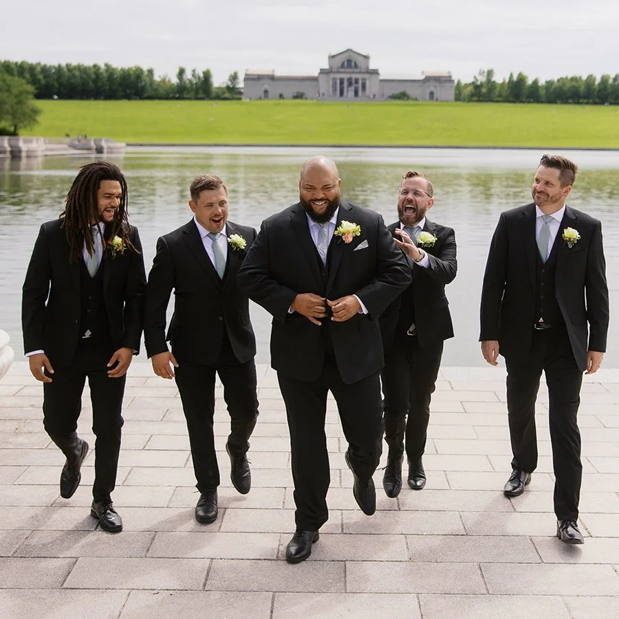 Groom and groomsmen walking in front of the St. Louis Art Museum with wedding bouquets designed by Belli Fiori.