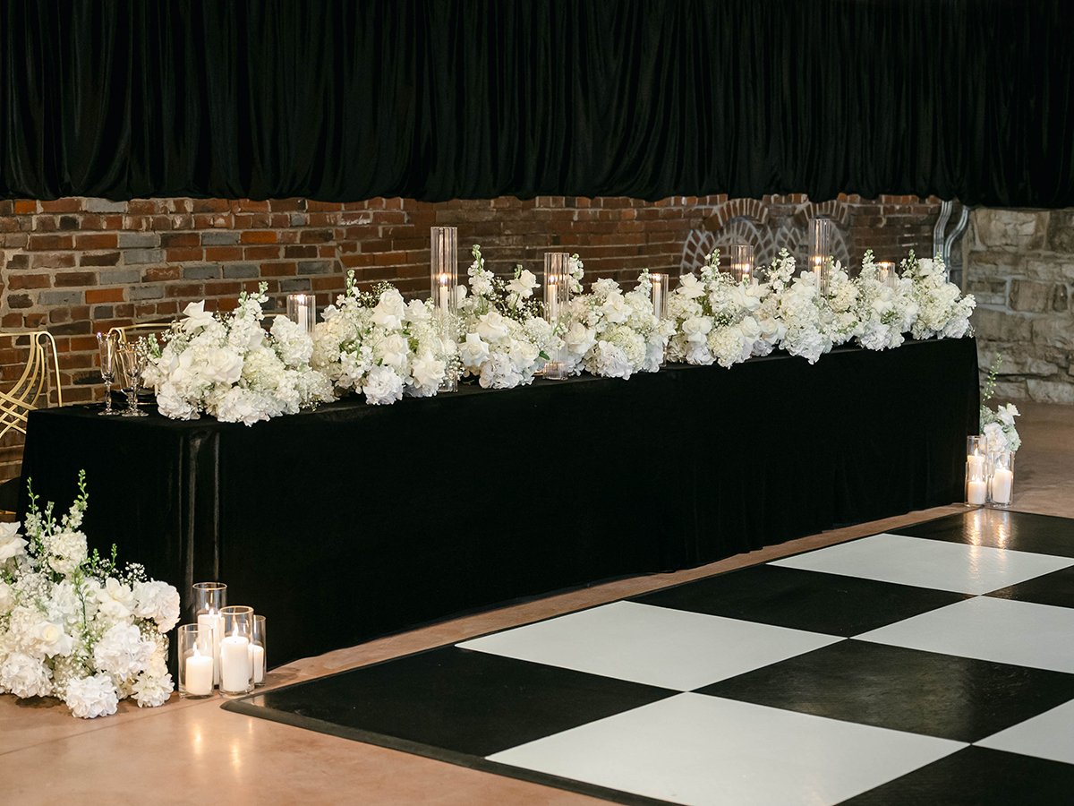 Black and white wedding head table with all white flowers at the Gatsby Events Venue in St. Louis.