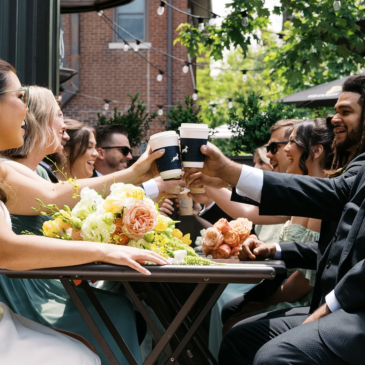 Bride and groom having coffee at their first date spot with flowers designed by Belli Fiori based in St. Louis.
