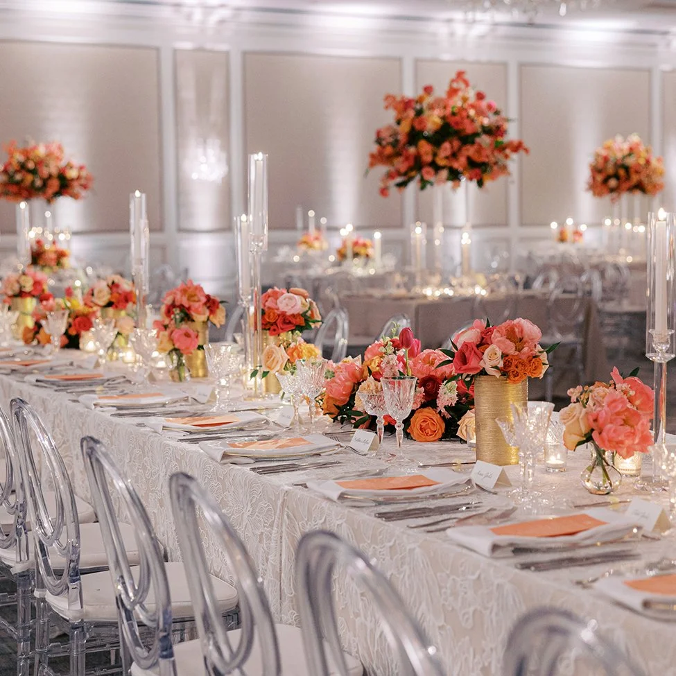 Pink and peach wedding flowers on a long table at the St. Louis Ritz Carlton Hotel.