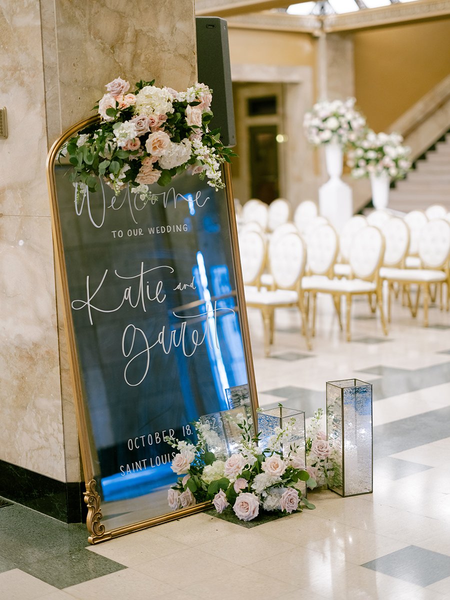 Wedding welcome sign with blush and white flowers for a wedding at the Stifel Theater in St. Louis.