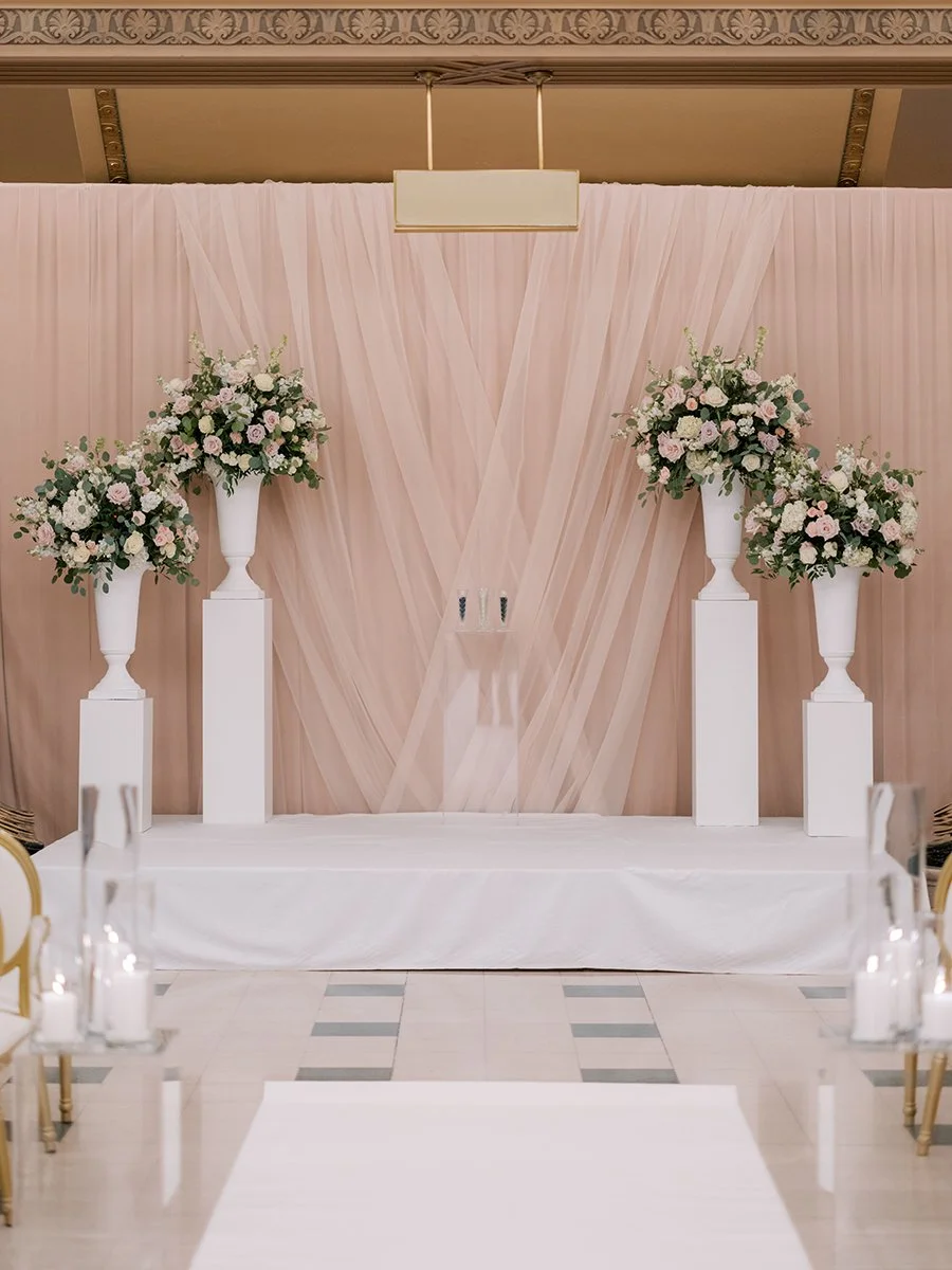 Wedding ceremony stage with blush and white flowers for a wedding at the Stifel Theater in St. Louis.
