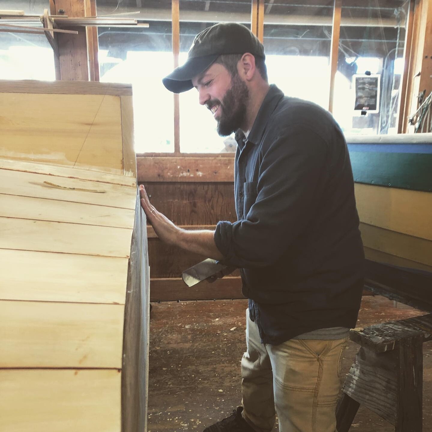 Josh Anderson works on the transom of a wooden boat