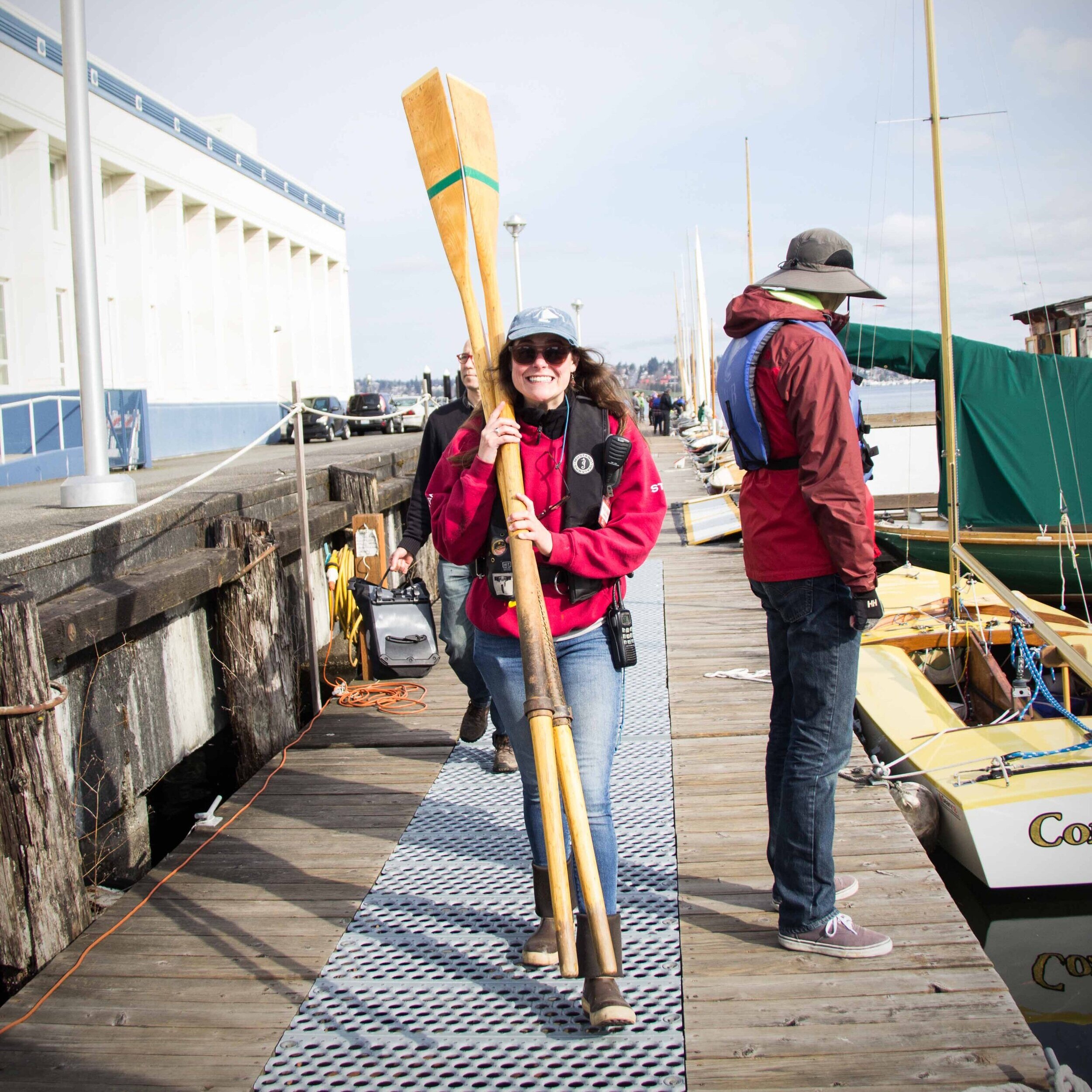 Shelby Allman carries rowboat oars while walking down the CWB dock