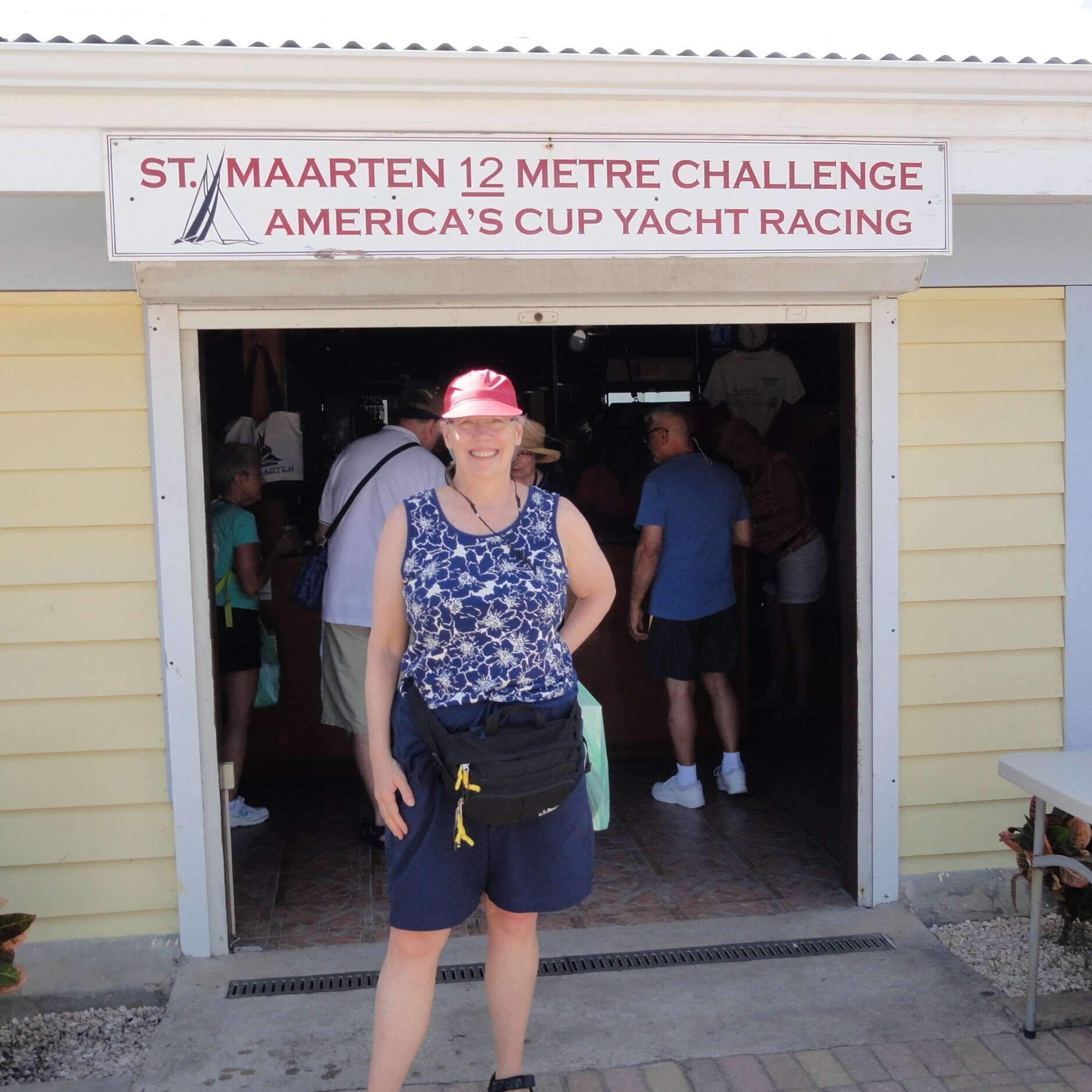 Nancy Engel stands in front of the St. Maarten Y12 meter challenge America's Cup Yacht Racing sign