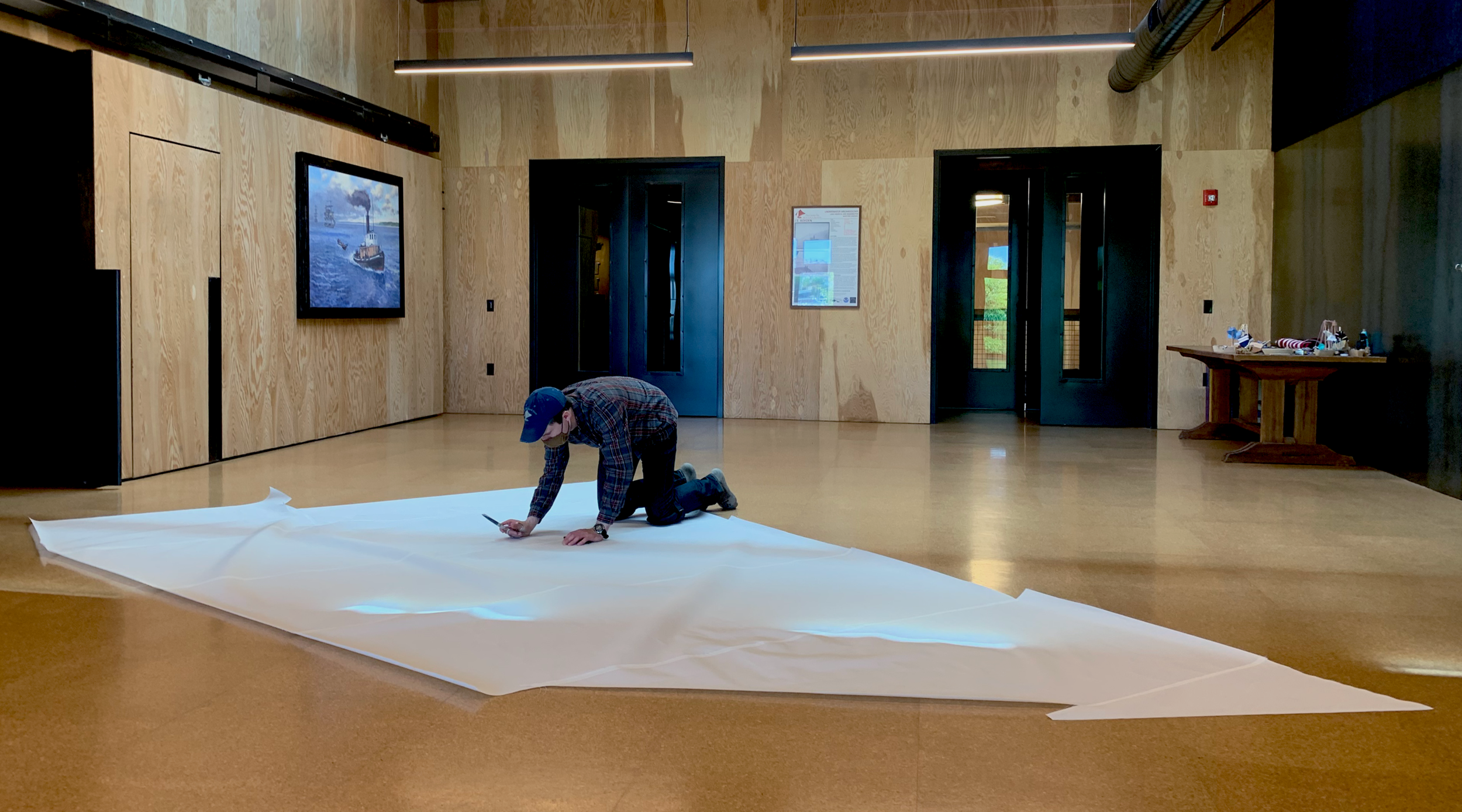 Volunteer lays out a sail in the CWB sail loft