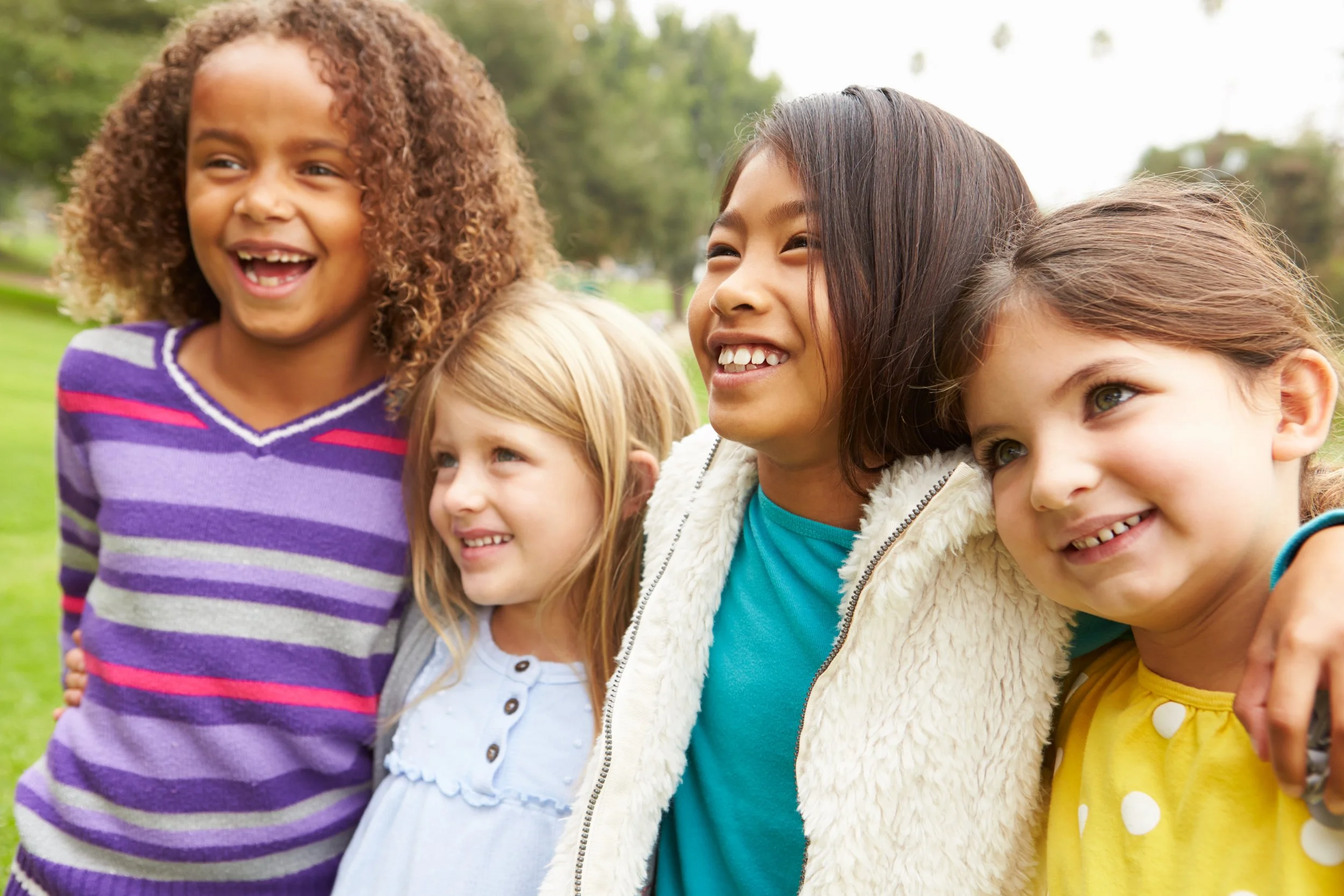 Group of young girls standing outdoors side by side and smiling