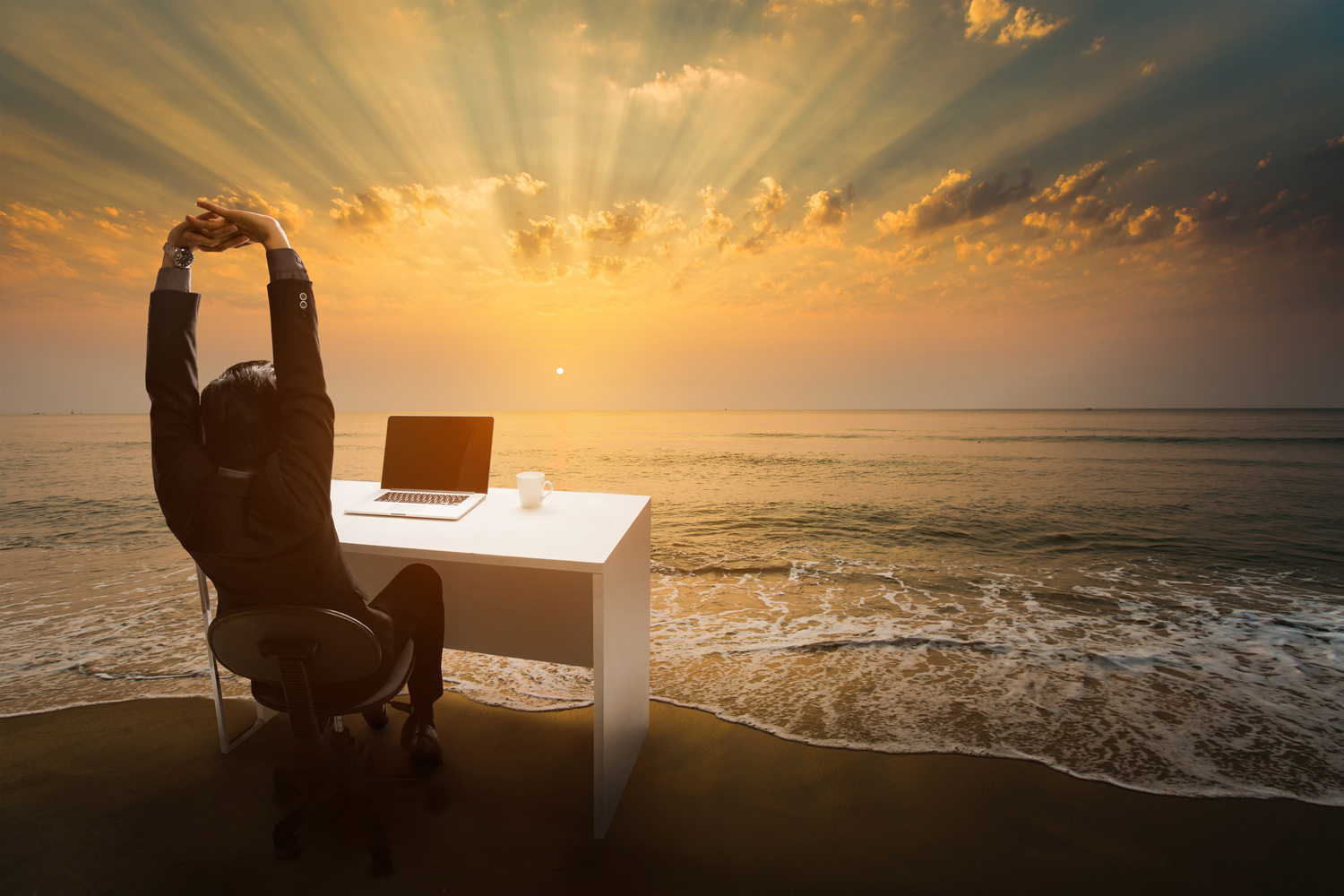 man-at-desk-beach-ocean-sunlight.jpg