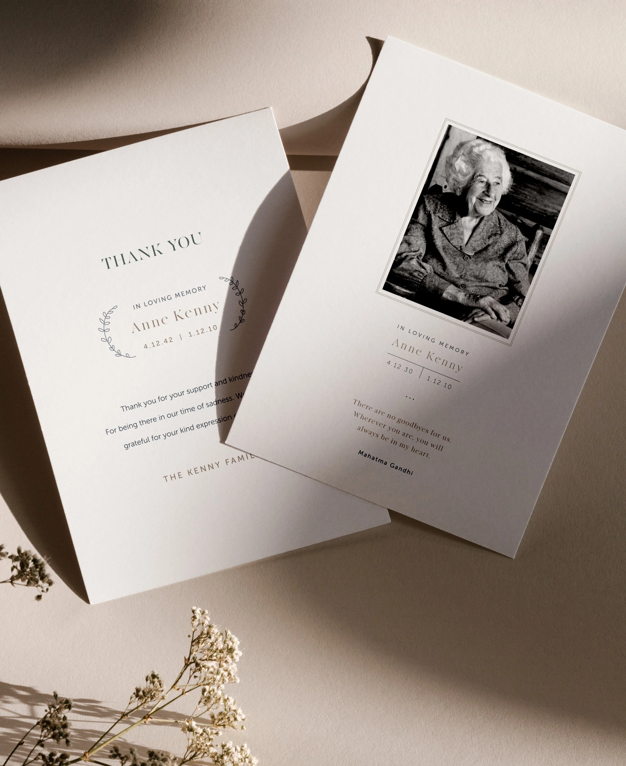 Memorial cards for Anne Kenny, one with her portrait and a heartfelt quote, and the other with a thank you message from her family, placed on a beige surface with dried flowers.