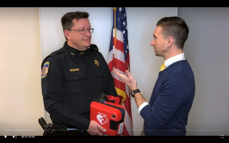 Police Chief Craig Bangert and President Bull discussing the Defibrillator and the fund raising efforts of the Chamber.