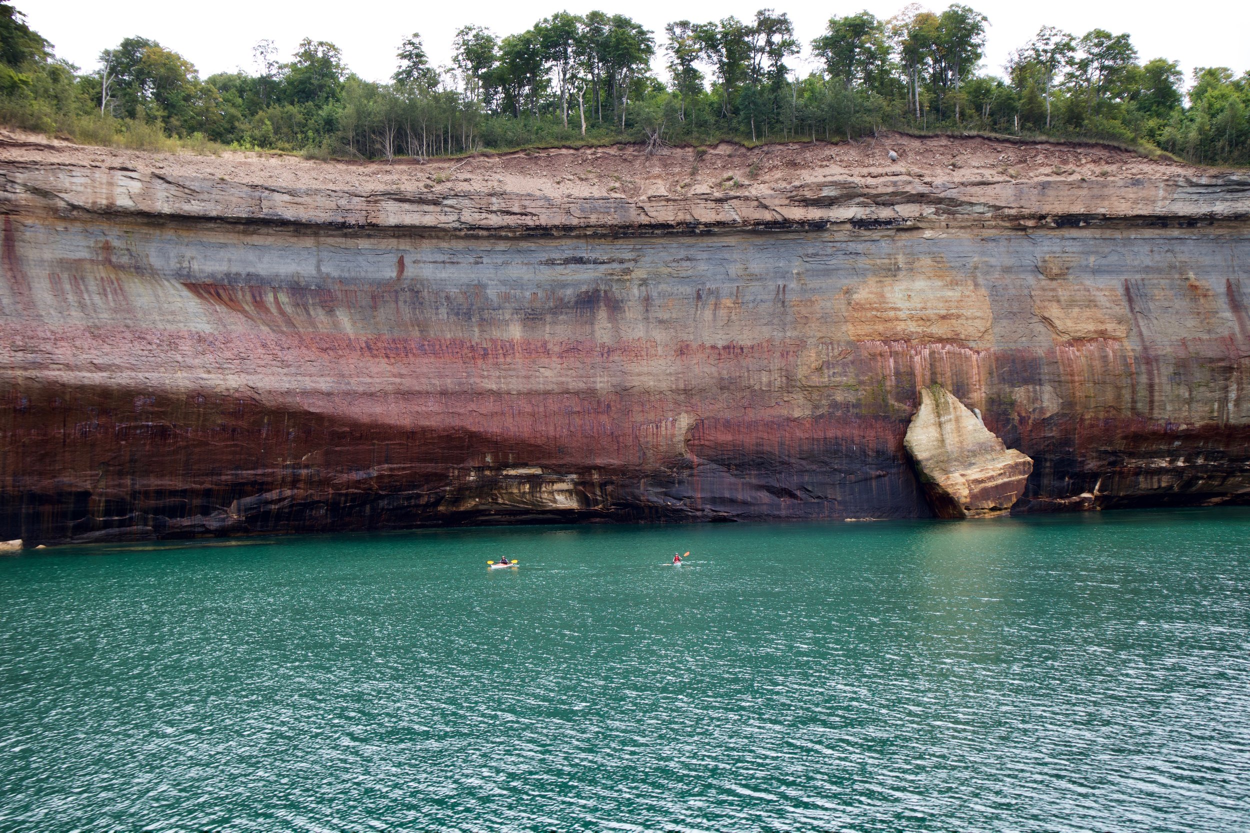 This picture gives some perspective on the height of the cliffs along the lakeshore - kayakers against the backdrop of 200 - 250 foot cliffs.