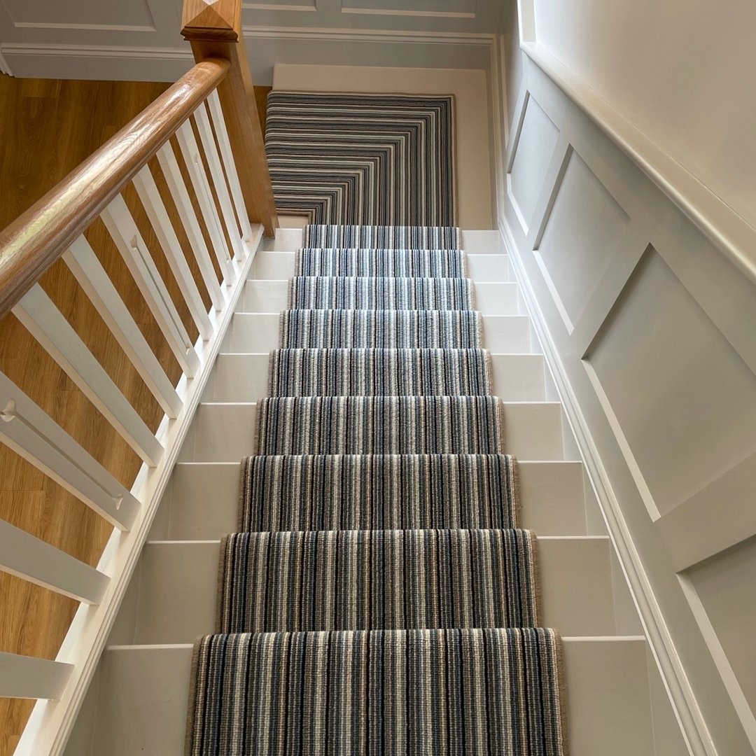 To the untrained eye this looks merely like a striped carpet runner, but upon closer inspection, this is a fantastic example of brilliant workmanship. 

It was stated that it was not possible to install this design, in a looped carpet, in this situat