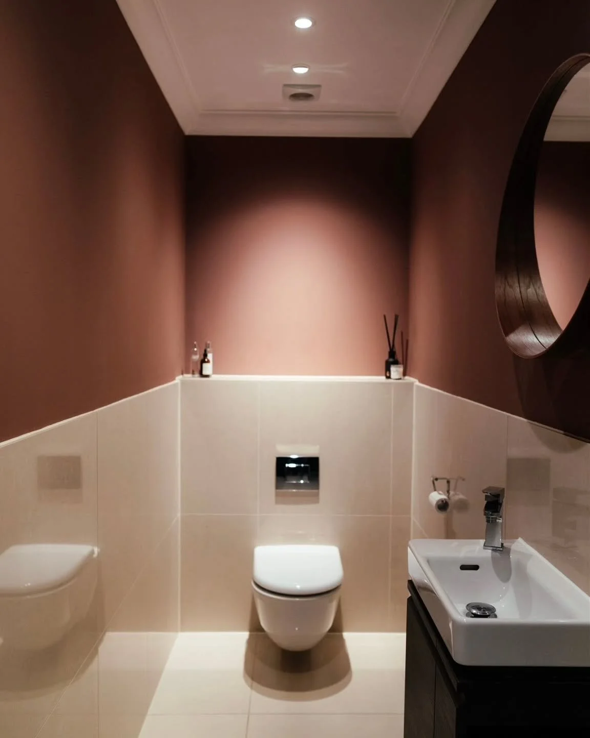 This cloakroom is a perfect balance of style and function with an added dash of drama. This on trend warm pinky brown hue has been teamed with cream gloss tiles and a sleek wall mounted toilet to create a crisp, clean, yet moody environment.

We do l
