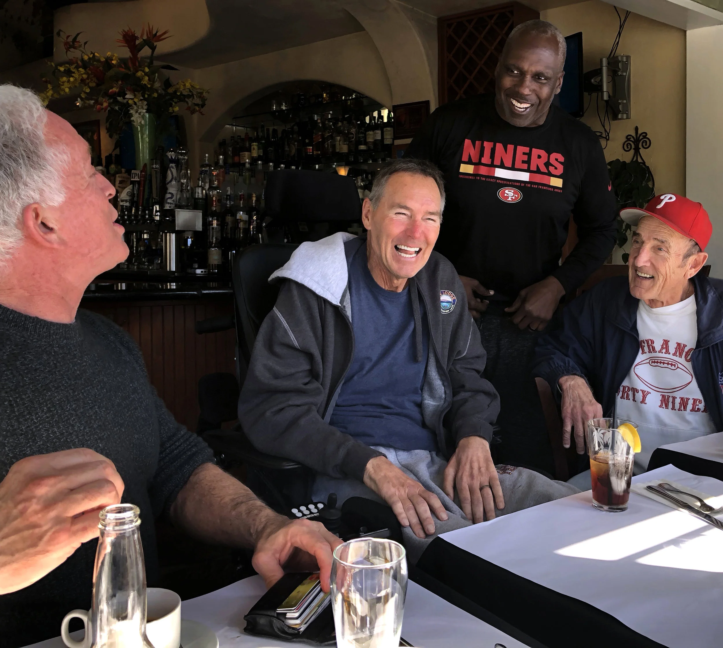 Mark Ibanez, Dwight Clark, Guy McIntyre, and Michael Zagaris laugh during lunch in Capitola, California, on February 13, 2018.