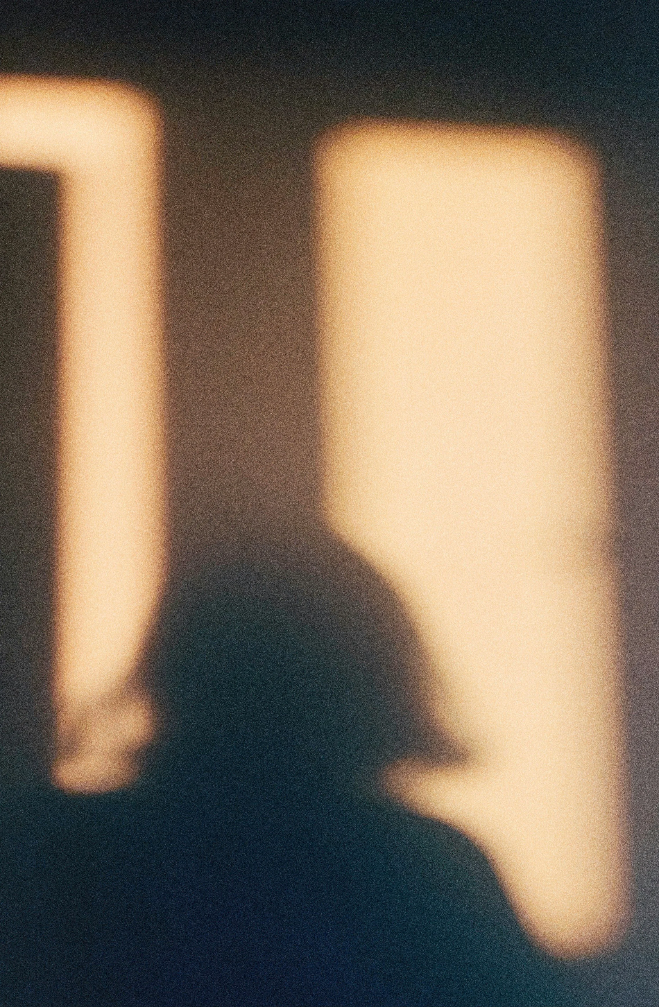 Blurred shadow of a person with long hair against illuminated windows or light panels.