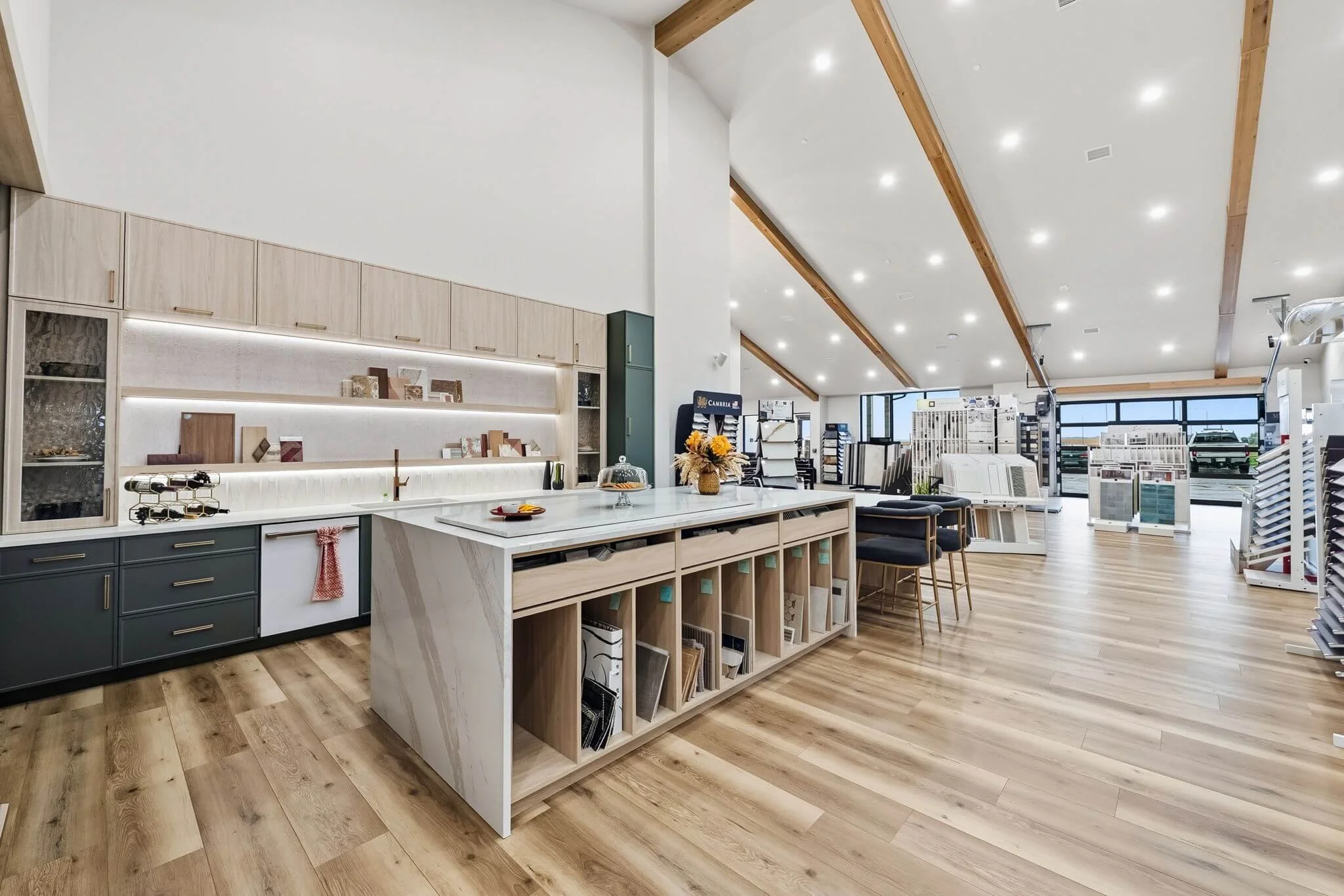 showroom, design, design studio, flooring, samples, kitchen, cabinets, quartz, light fixtures, plumbing fixtures, wood beams, beams, vaulted ceiling, glass garage door