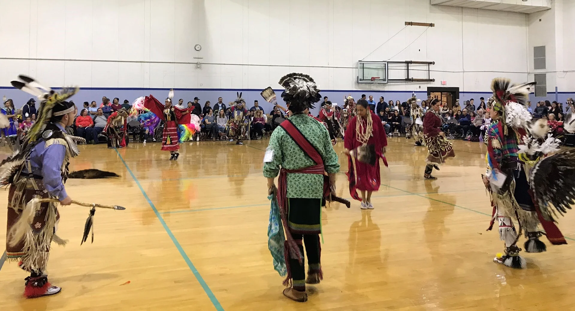 Final round contest during the Red Dress Special. Teen and adult men’s traditional dancers standing guard around the parameter.