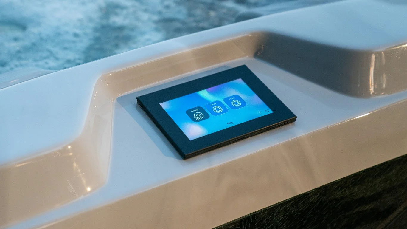A digital 880 Controls panel is built into the side of a white hot tub near the bubbling water.
