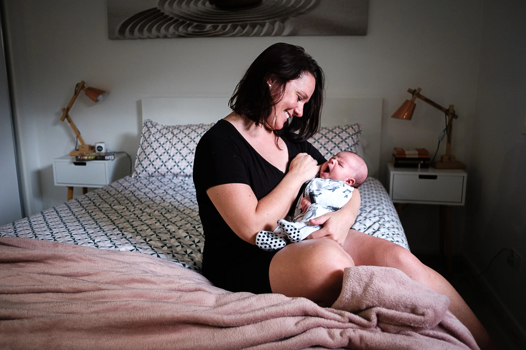 Mother and newborn on bed relaxed in-home newborn photography gold coast without props
