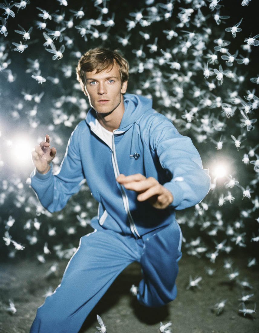 analog_film_photo_built_in____flash_____kettil_thorbj_rn_walther__twenty_five_years_old_man__short_dark_blond_hair__blue_eyes__light_blue_tracksuit_____dances____wildly_in_a_swarm_of_mos_281466779.jpg