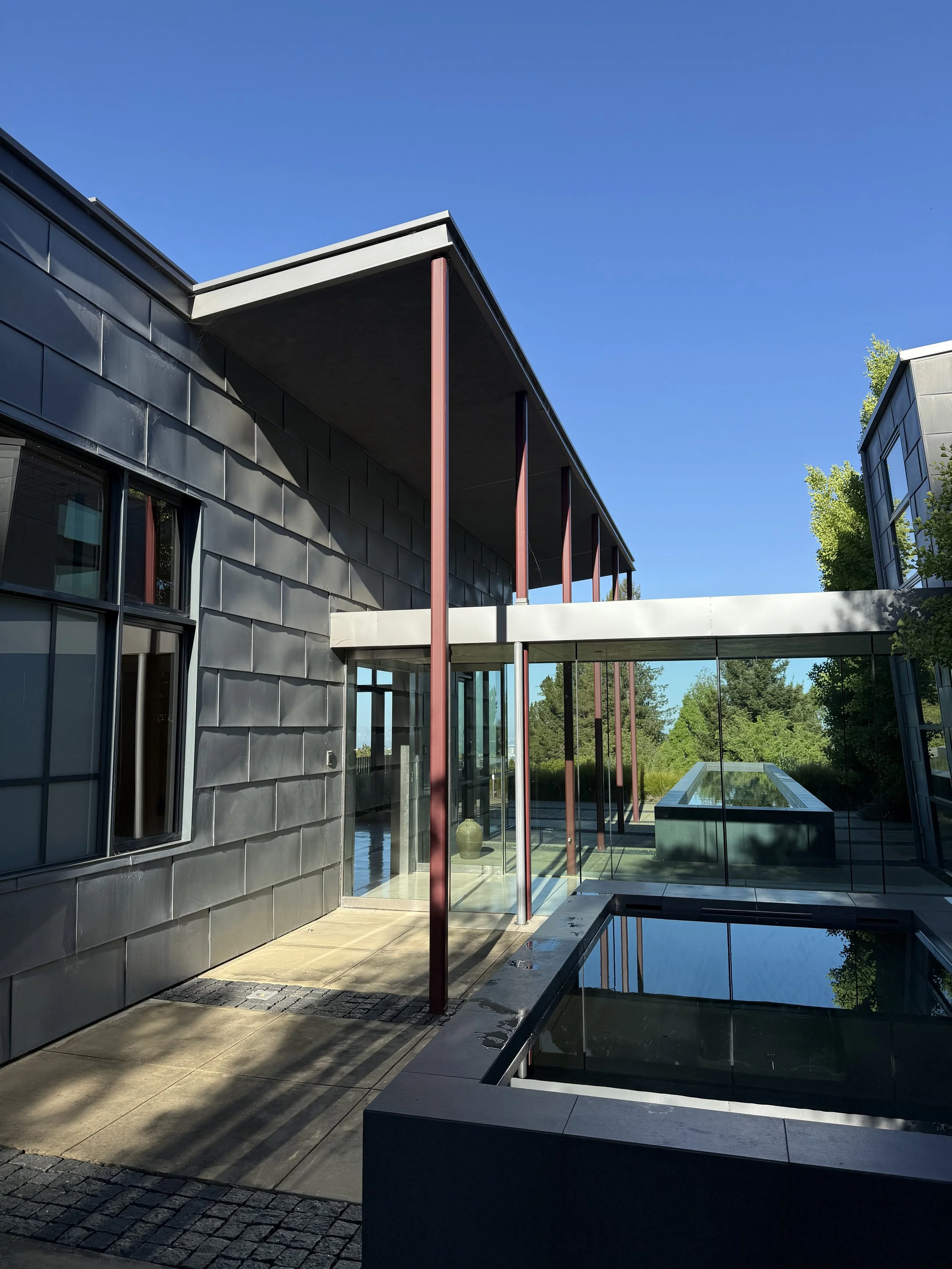 Close-up of shallow water with patterns of sunlight reflecting on the sandy bottom with small pebbles scattered.