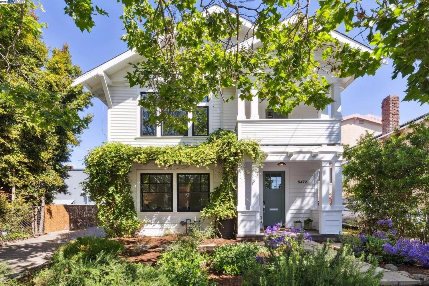 Modern backyard with a swimming pool, lounge chairs, desert plants, and a patio with outdoor furniture and trees.