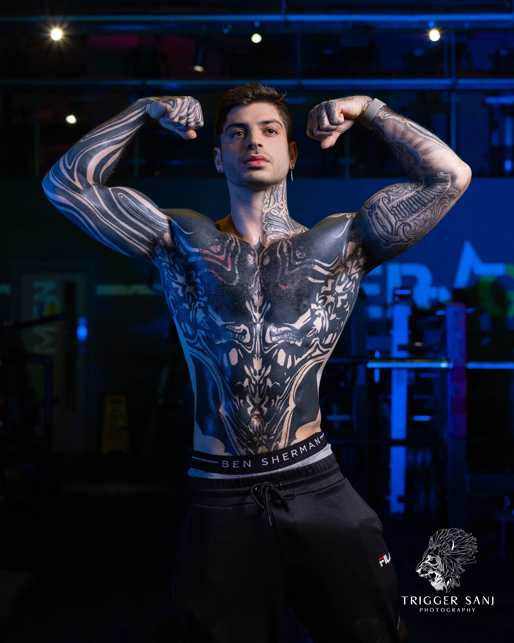 male personal trainer posing in front of a mirror in energym