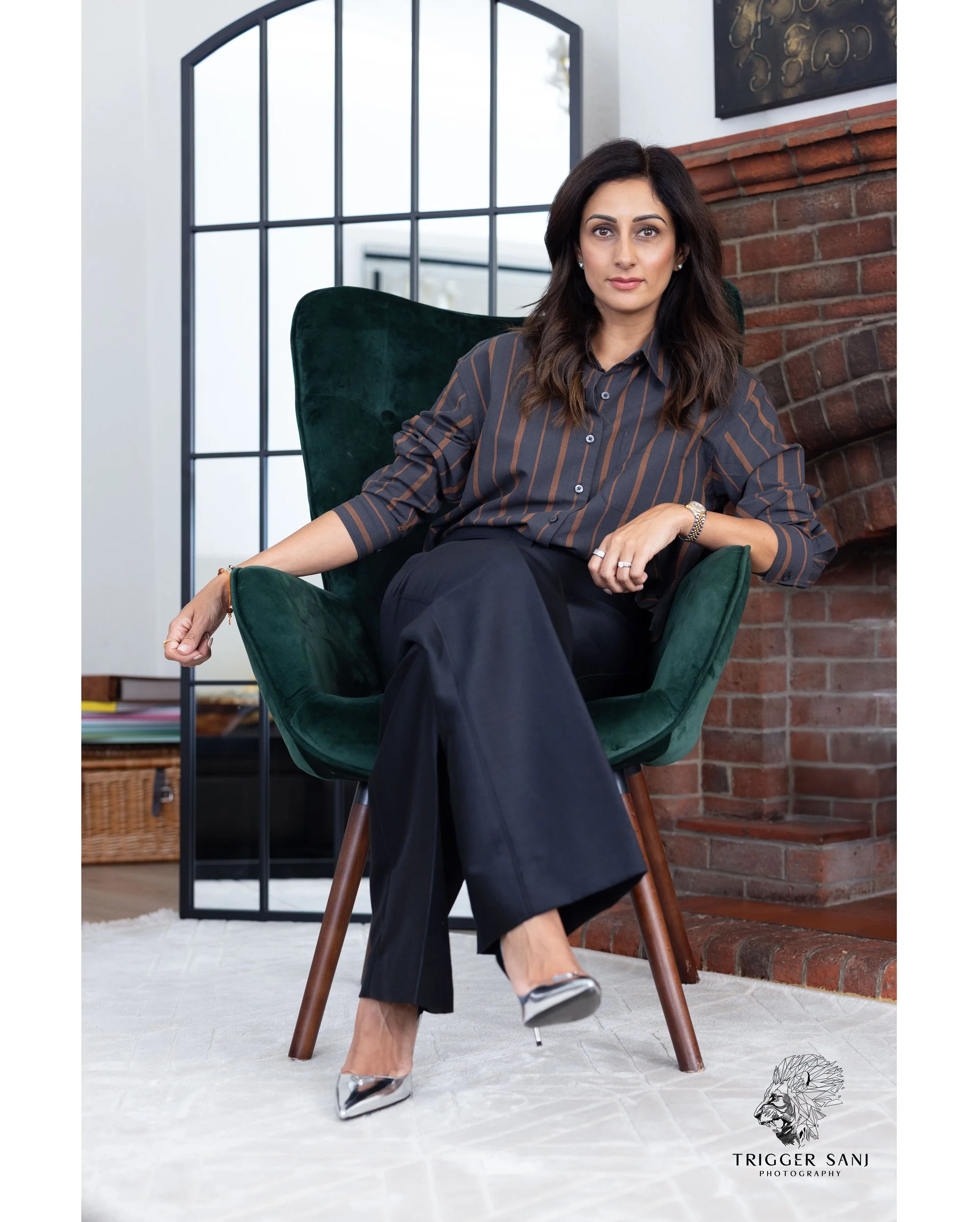 Female business owner sitting on her chair with a fireplace in the background