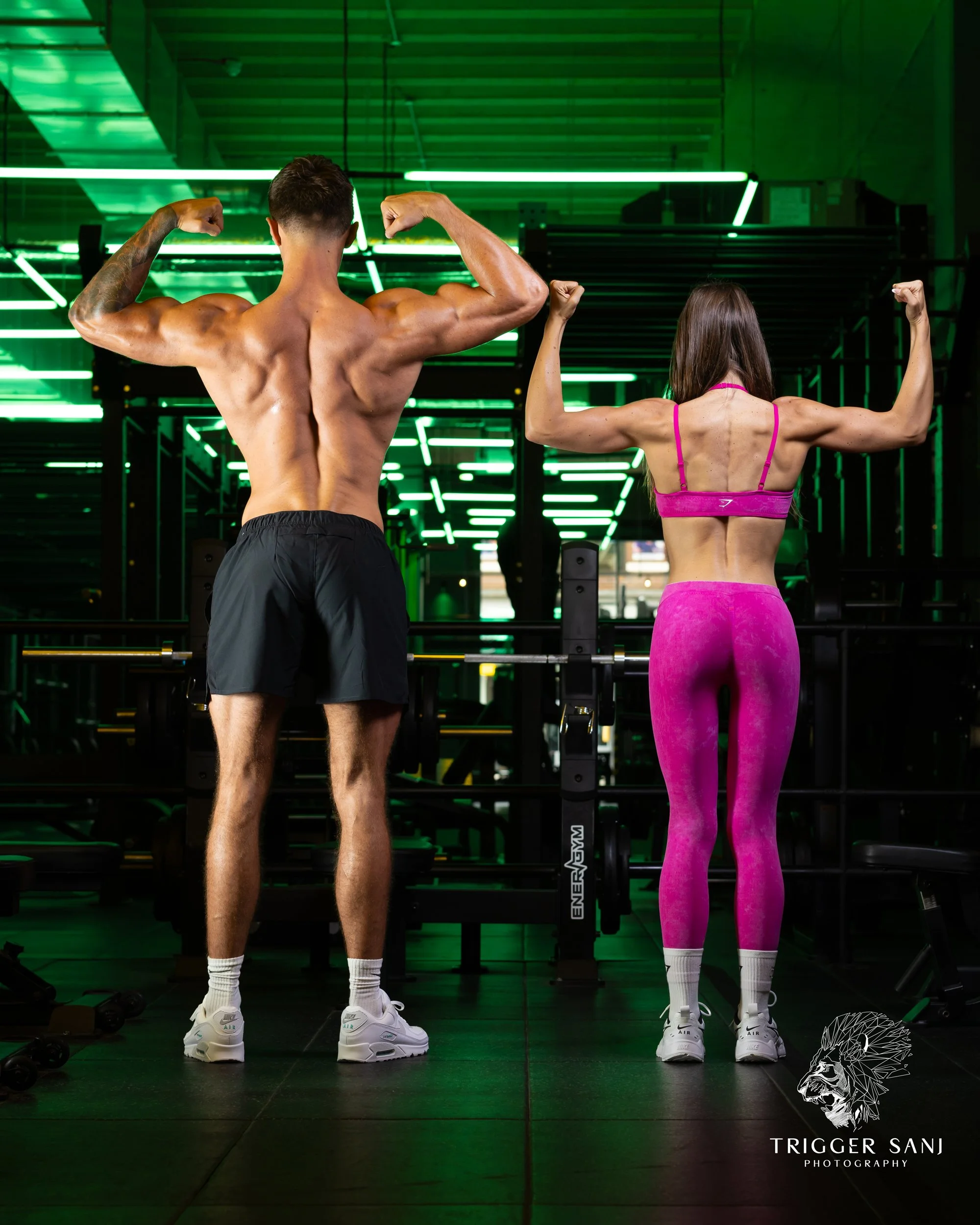 A couple with their backs turned to the camera to show their back muscles