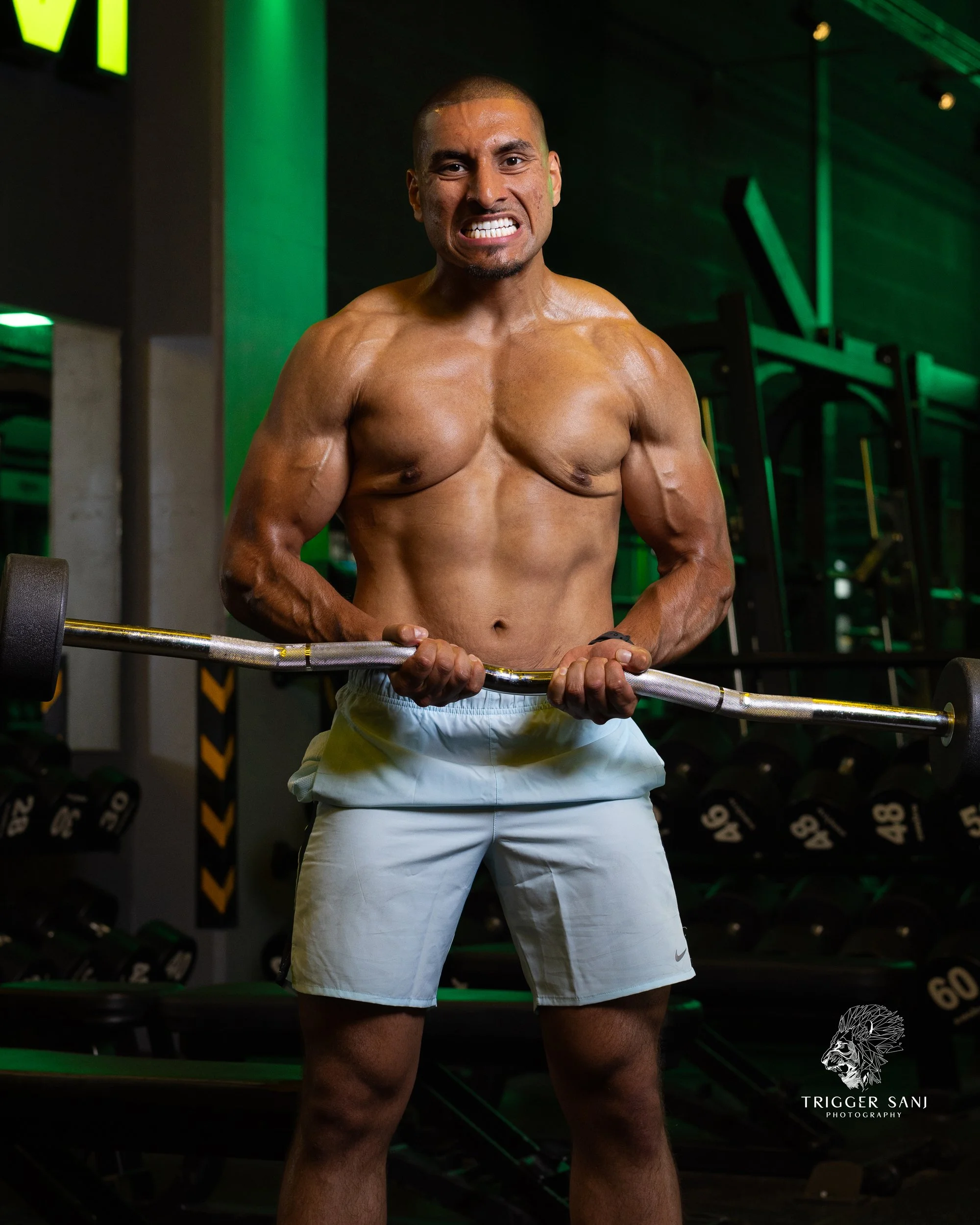 Male personal trainer using ezy bar to train biceps in Energym West Ealing