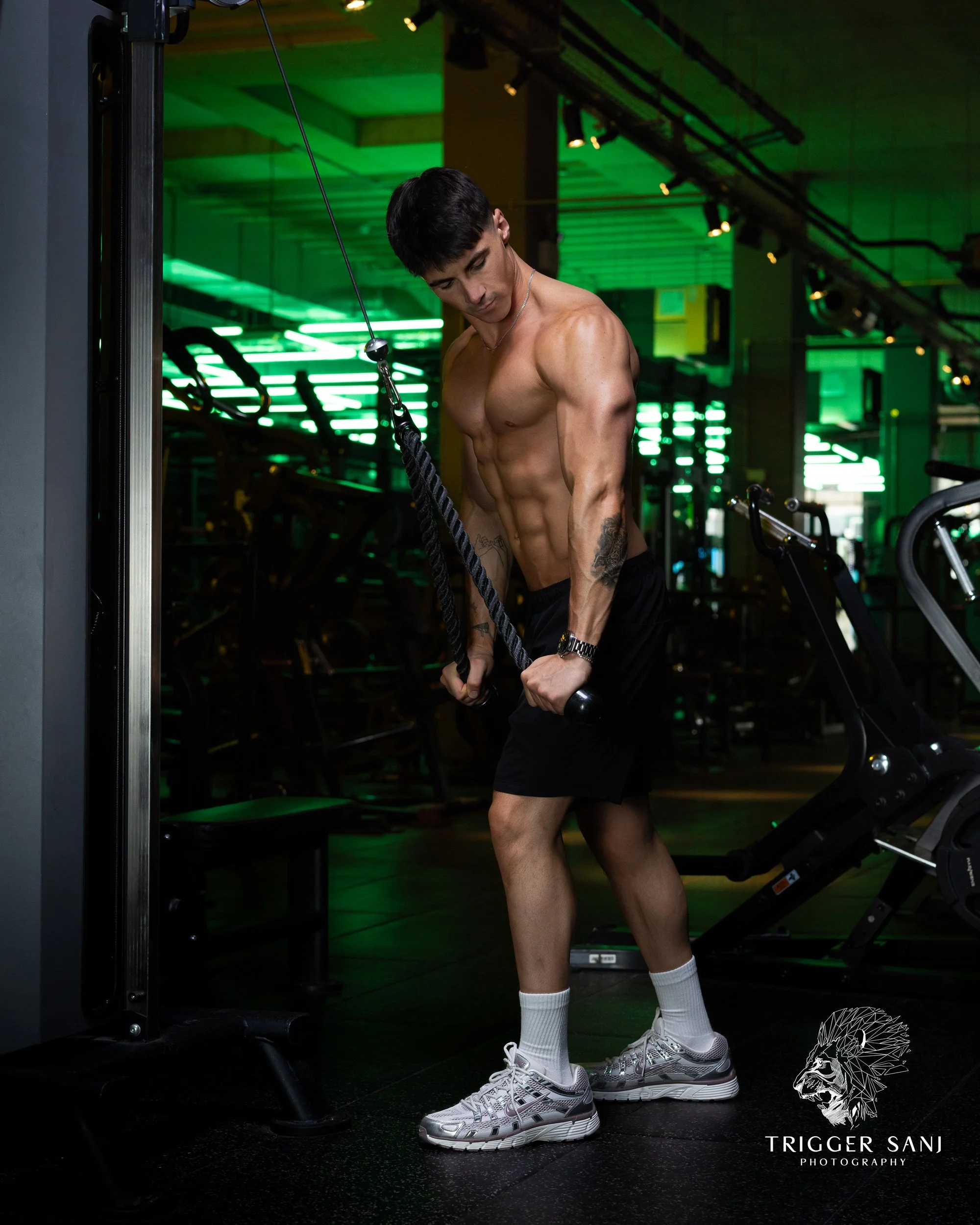 Male personal trainer doing tricep rope extensions in Energym Ealing