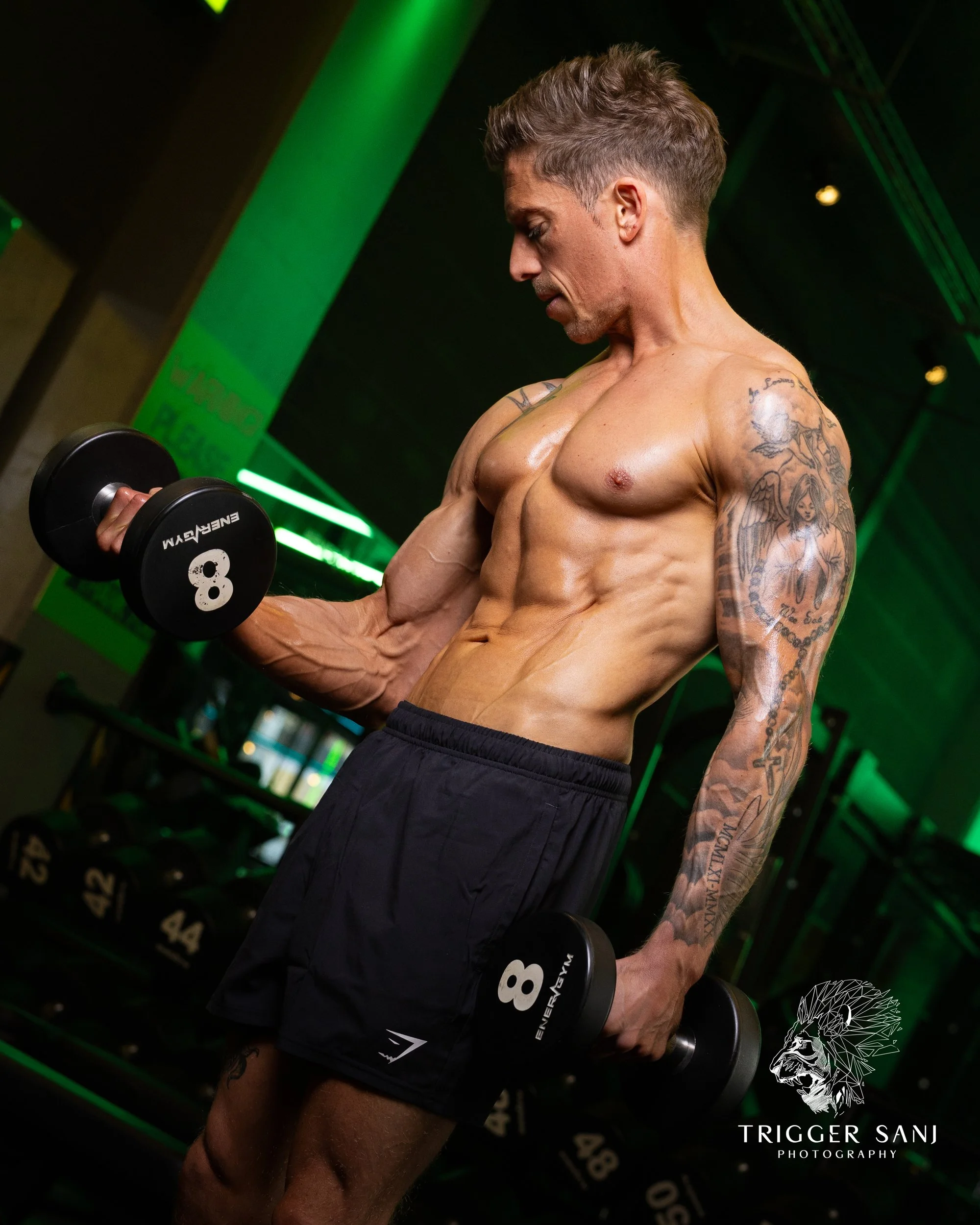 Male personal trainer doing a bicep curl in Energym West Ealing
