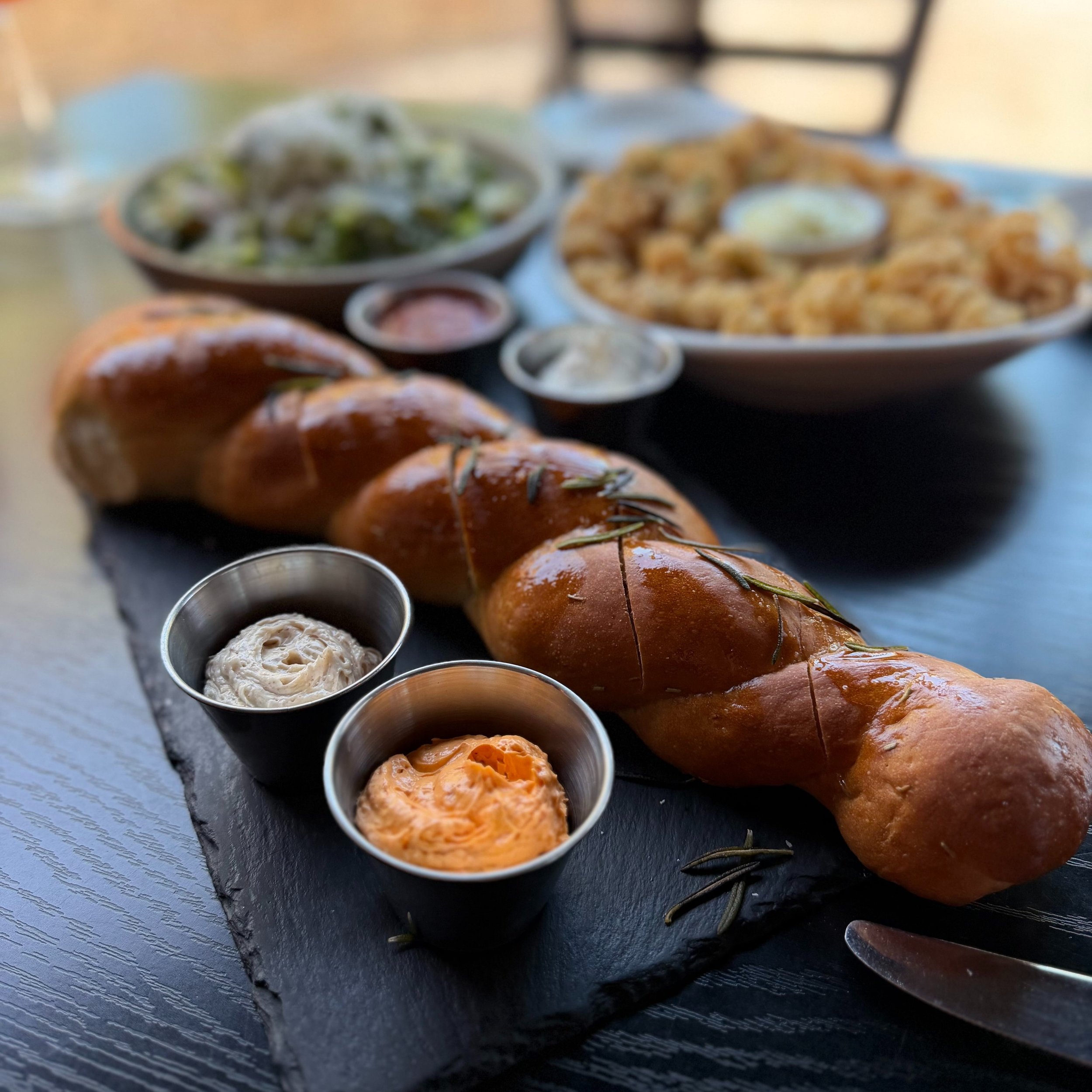 🍝✨ Bread goals unlocked at Locale Italian Kitchen in Las Vegas!
This gorgeous rosemary braided loaf, served warm with that silky roasted garlic butter and spicy calabrian chili butter, is pure heaven. Paired with a refreshing Aperol Spritz or Locale
