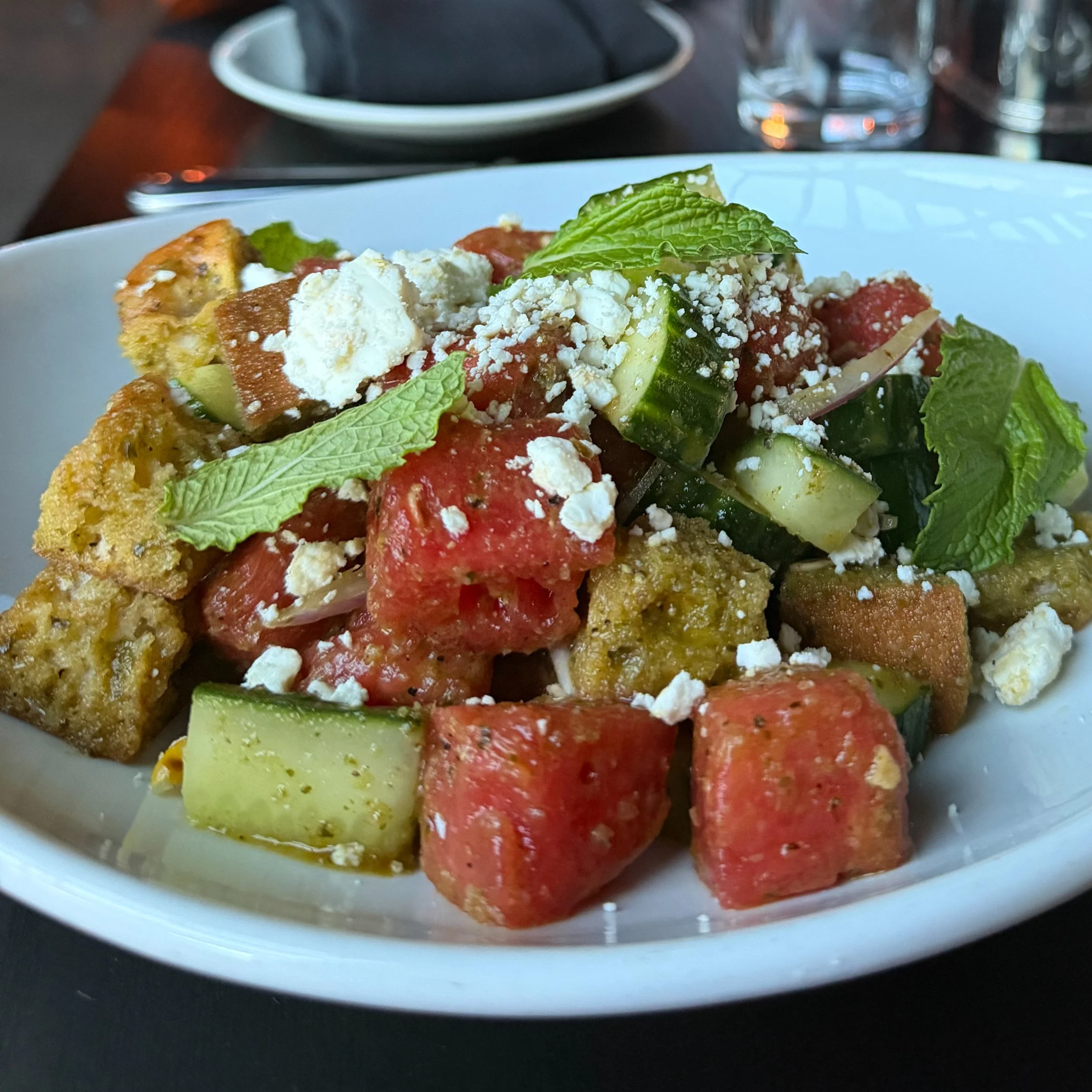 Juicy watermelon, sharp red onions, and crispy housemade bread cubes tossed in a bright lime-mint vinaigrette, finished with goat cheese. The Watermelon Panzanella at Locale Italian Kitchen is summer on a plate &mdash; refreshing, sweet, savory, and 