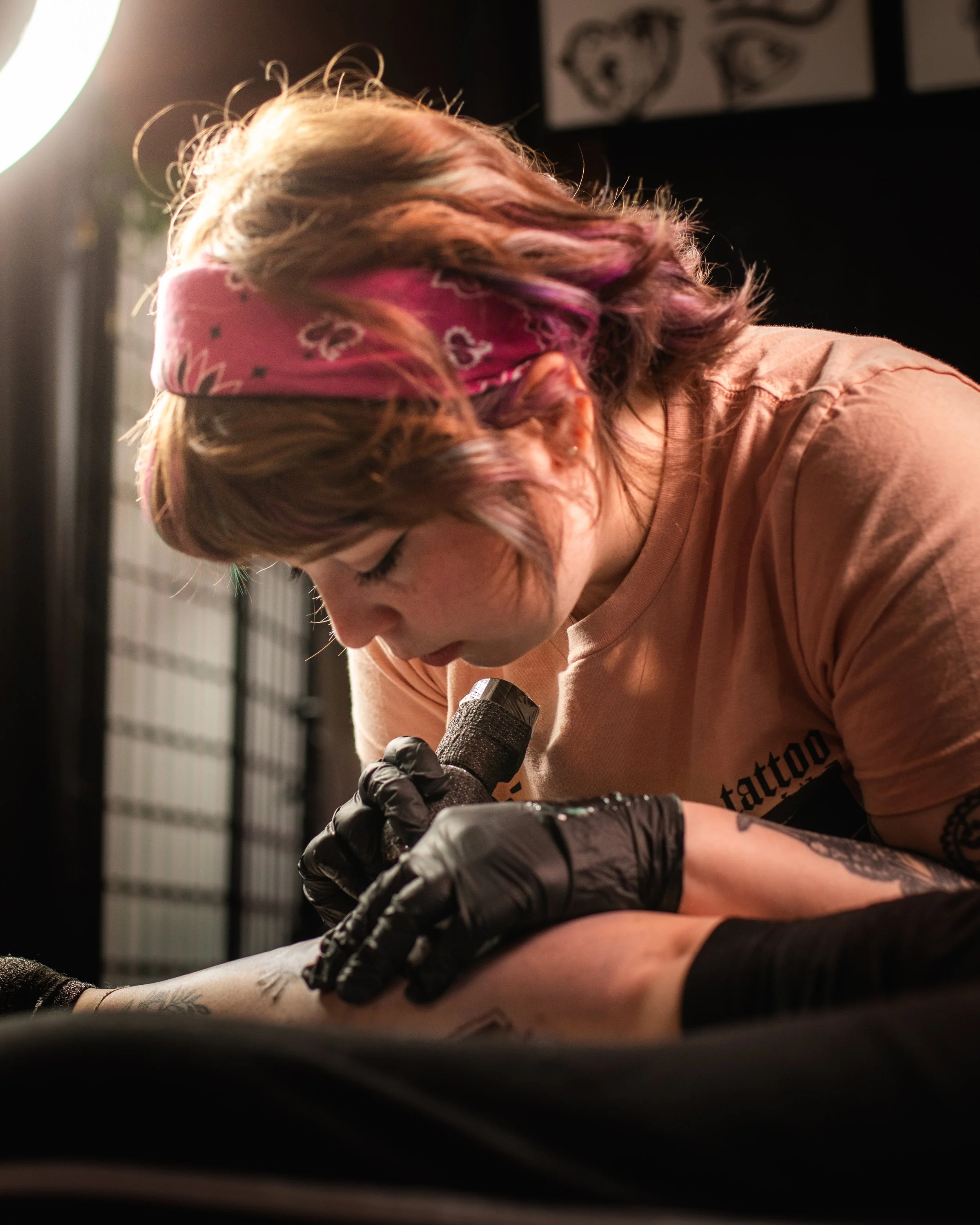 a female tattoo artist tattoos a client