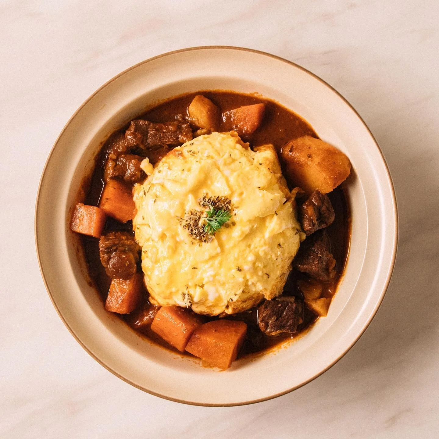 紅酒燉牛肉歐姆蛋

前陣子在好市多買了一些里肌牛排，試了幾次總覺得沒特別喜愛，於是就這樣在冷凍櫃住了些時日。

趁著颱風天想煮一鍋配飯或醮著麵包吃的燉物，突然想起那些牛排，就決定煮可以在30分鐘內搞定的紅酒燉牛肉。

將快速翻攪好的半熟歐姆蛋置於白飯上，再淋上醬汁，好像回到在小餐館的時光。