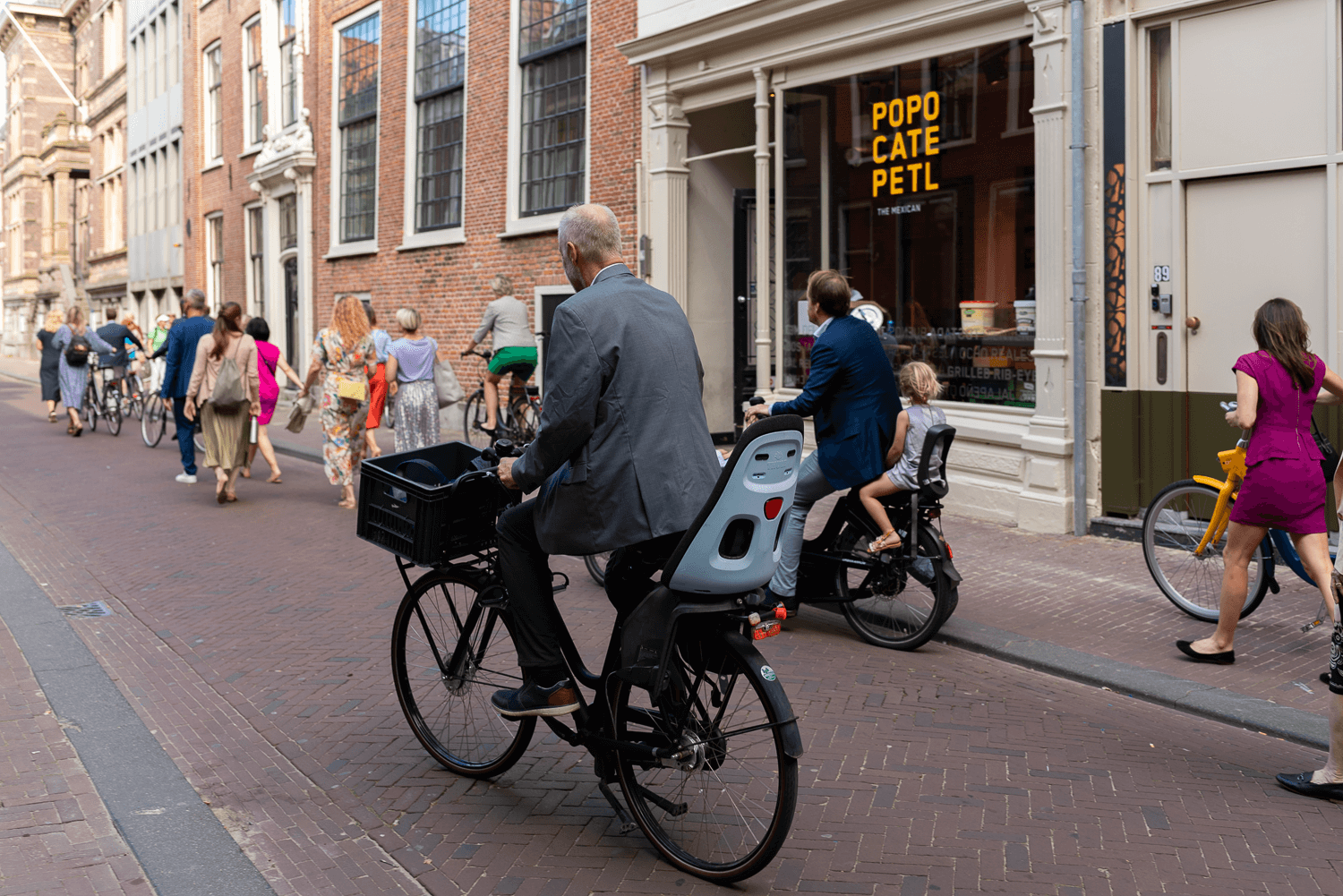 Small Wedding in Haarlem by Vicky McLachlan Photography_Family guest riding his bike down the street_1.png