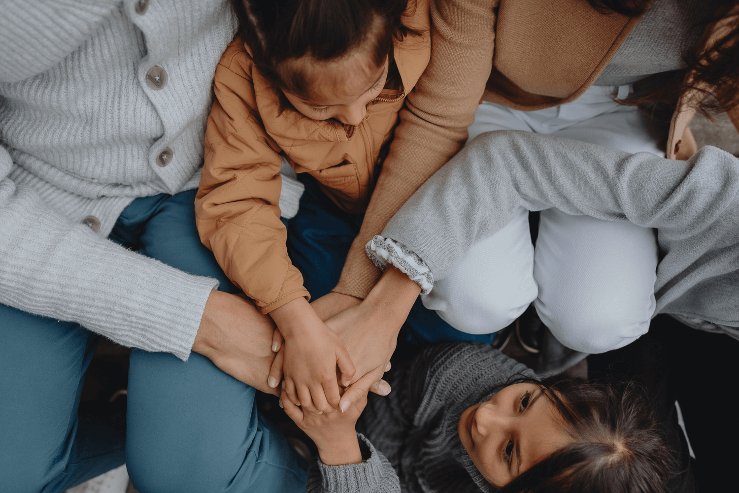 Family Photoshoot in Amsterdam by Vicky McLachlan Photography - American Family holding hands while sitting together on a staircase in front of a Dutch house on Brouwersgracht-1.png