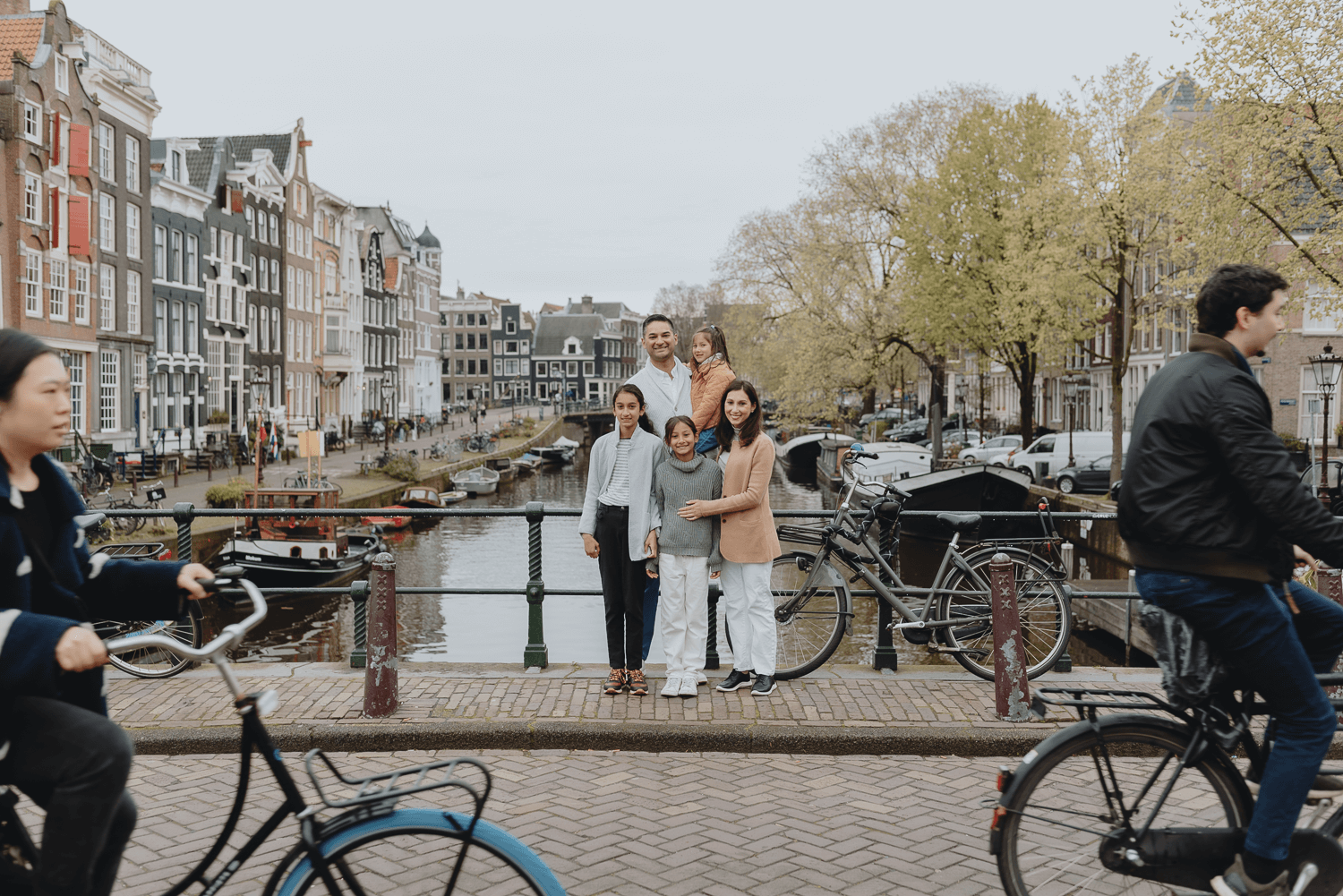 Family Photoshoot in Amsterdam by Vicky McLachlan Photography - American Family standing together on a bridge on Brouwersgracht with bikes going by-1.png