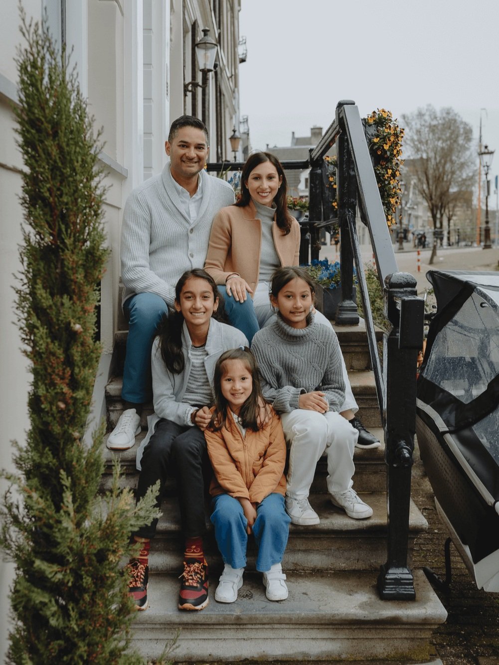 Family Photoshoot in Amsterdam by Vicky McLachlan Photography - American Family sitting together on a staircase in front of a Dutch house on Brouwersgracht-1.png