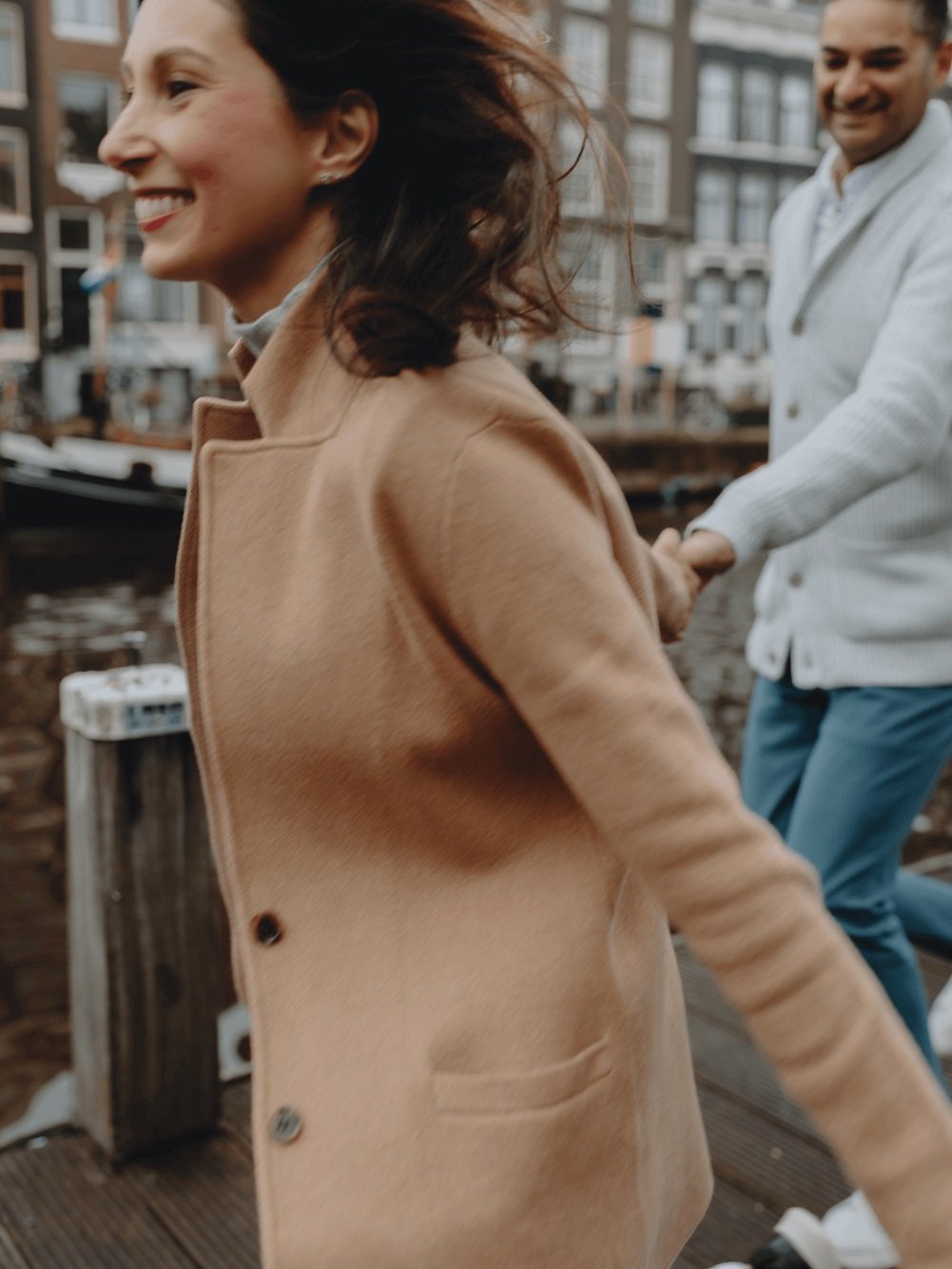Family Photoshoot in Amsterdam by Vicky McLachlan Photography - American Family with husband and wife running together while holding hands on a dock next to a Dutch canal_1-1.png