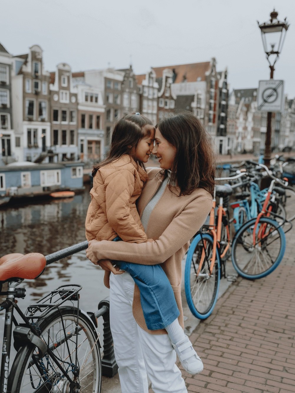 Family Photoshoot in Amsterdam by Vicky McLachlan Photography - American Family with mom and daughter holding each other in front of a canal on Brouwersgracht-1.png