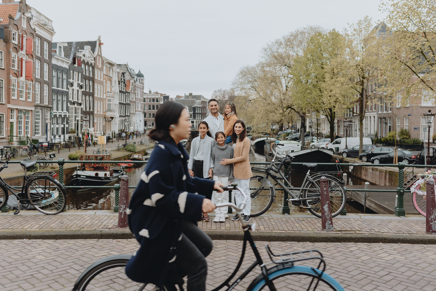 Family Photoshoot in Amsterdam by Vicky McLachlan Photography | Fun photo of an American Family standing together in Amsterdam with a woman on a bike photoboming the photo.-1.png