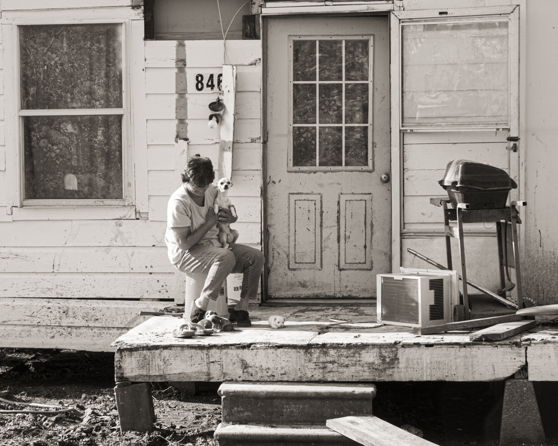 This woman’s house and land were destroyed in a Delta flood.. She had a dog with several near born pups to keep her company.
