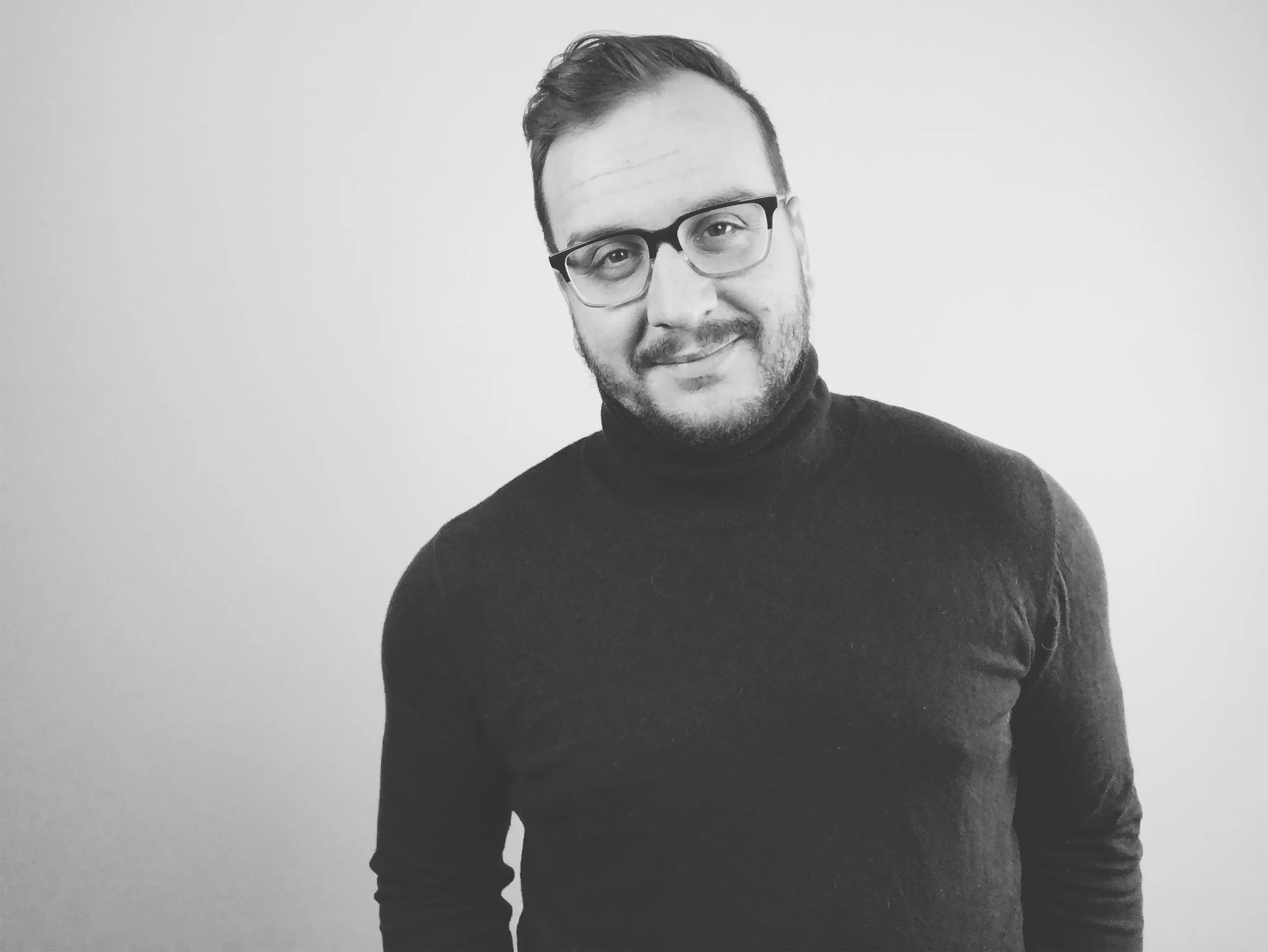  Image Description: a black and white studio photo of Matt looking at the camera. 