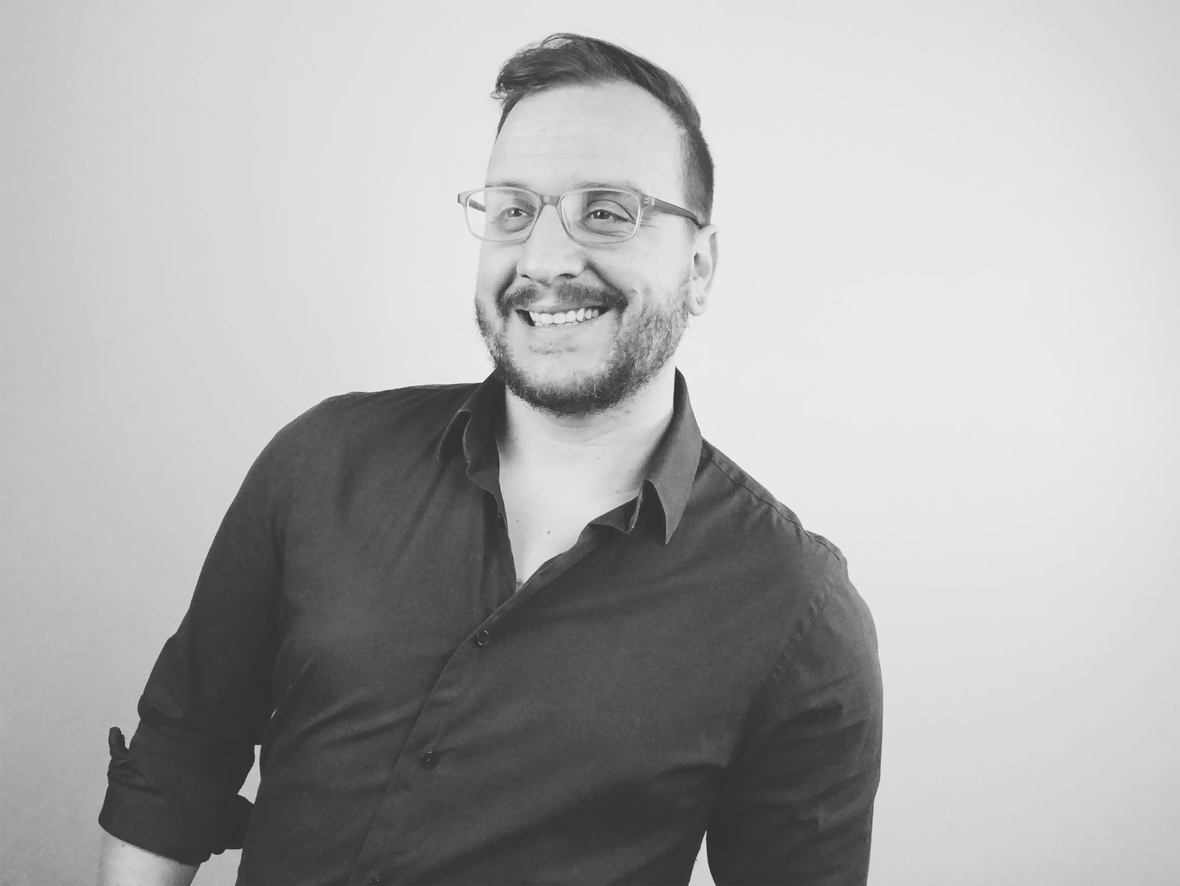  Image Description: a black and white studio photo of Matt smiling. 